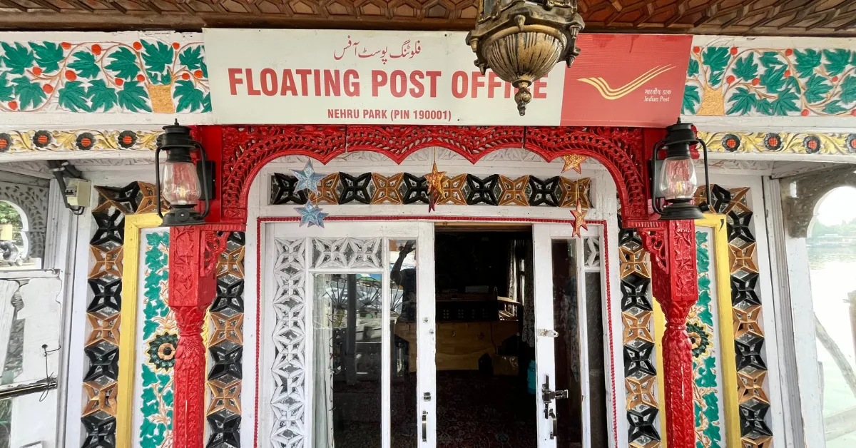 The entrance to the two-room houseboat features Kashmiri woodwork, floral carvings, and India Post’s signature colours.