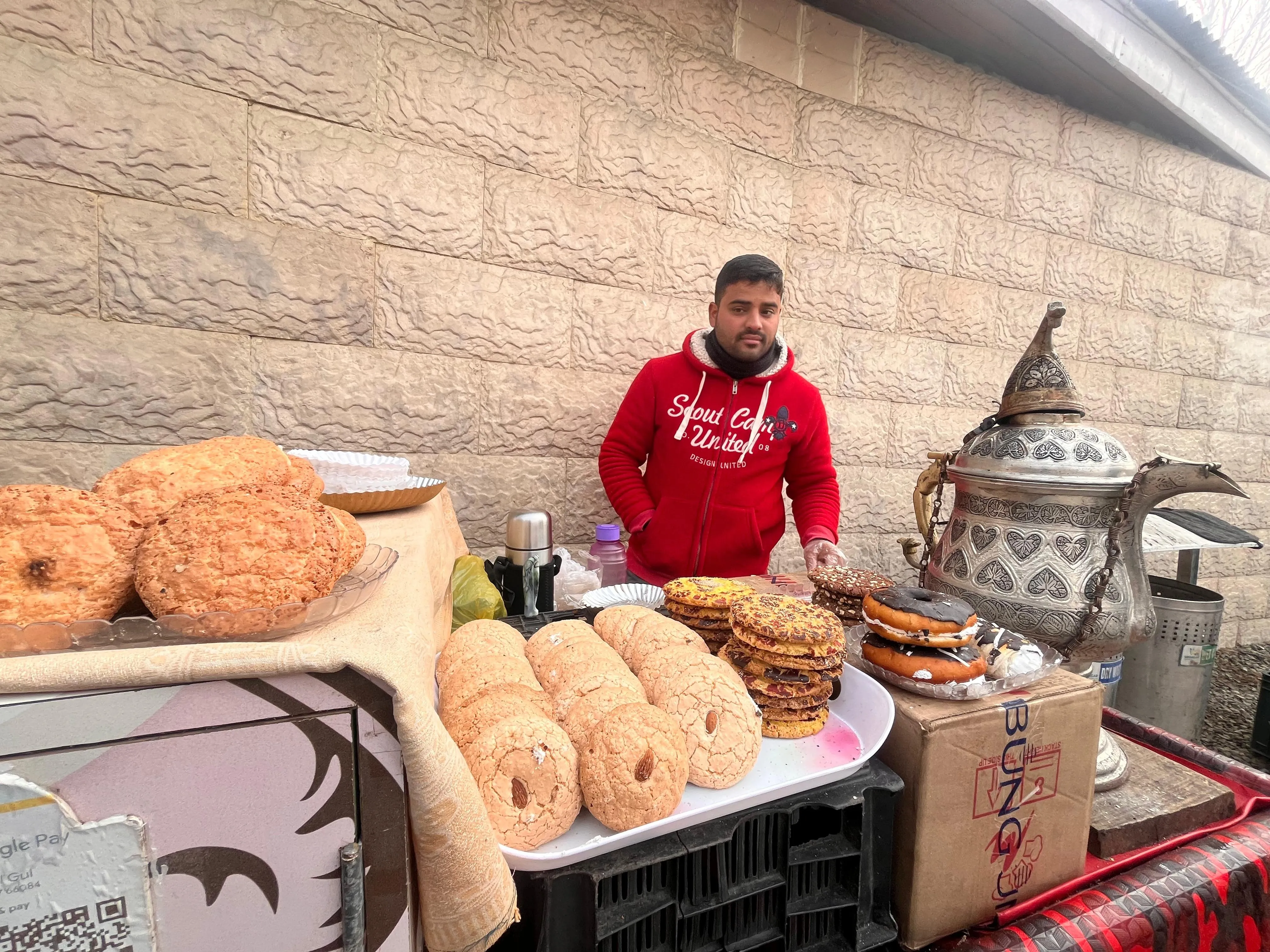 Outside the chrysanthemum garden in Srinagar, Kashmiri Kehwa seller Aminul Gul waits with his cart as visitors stream in for the floral show..