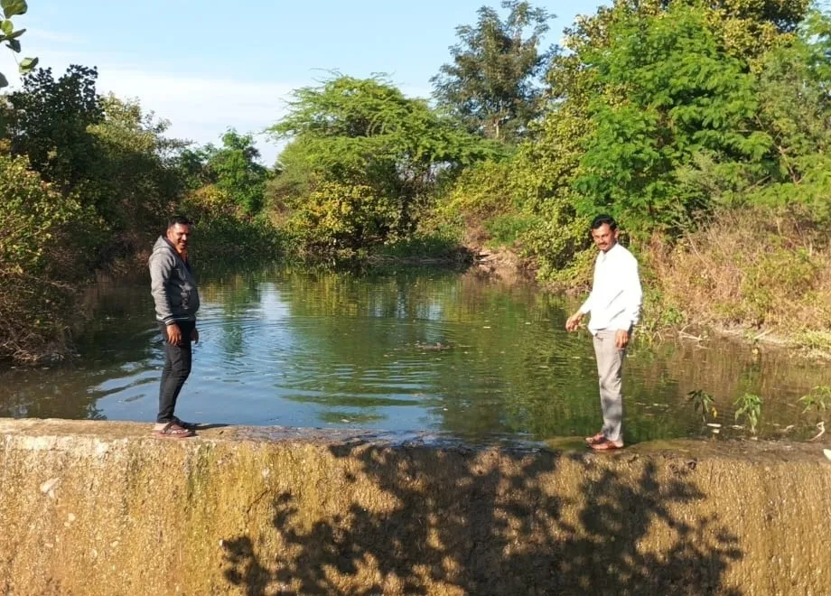 Villagers stading atop a Kolhapuri weir raised in Banswargaon