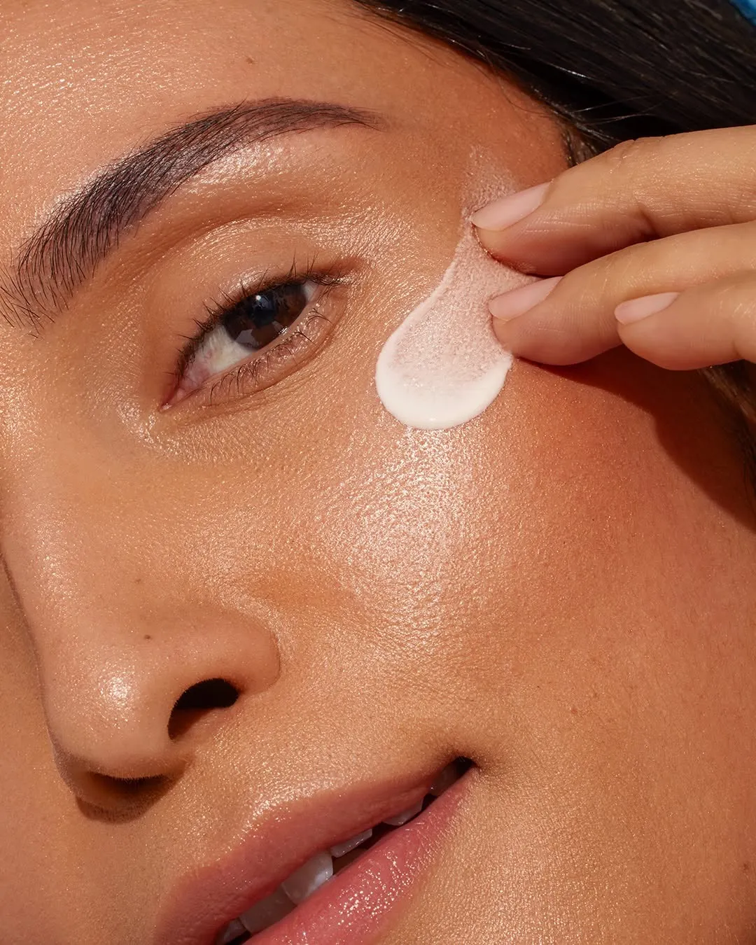 A woman applying sunscreen with SPF 30 on her face
