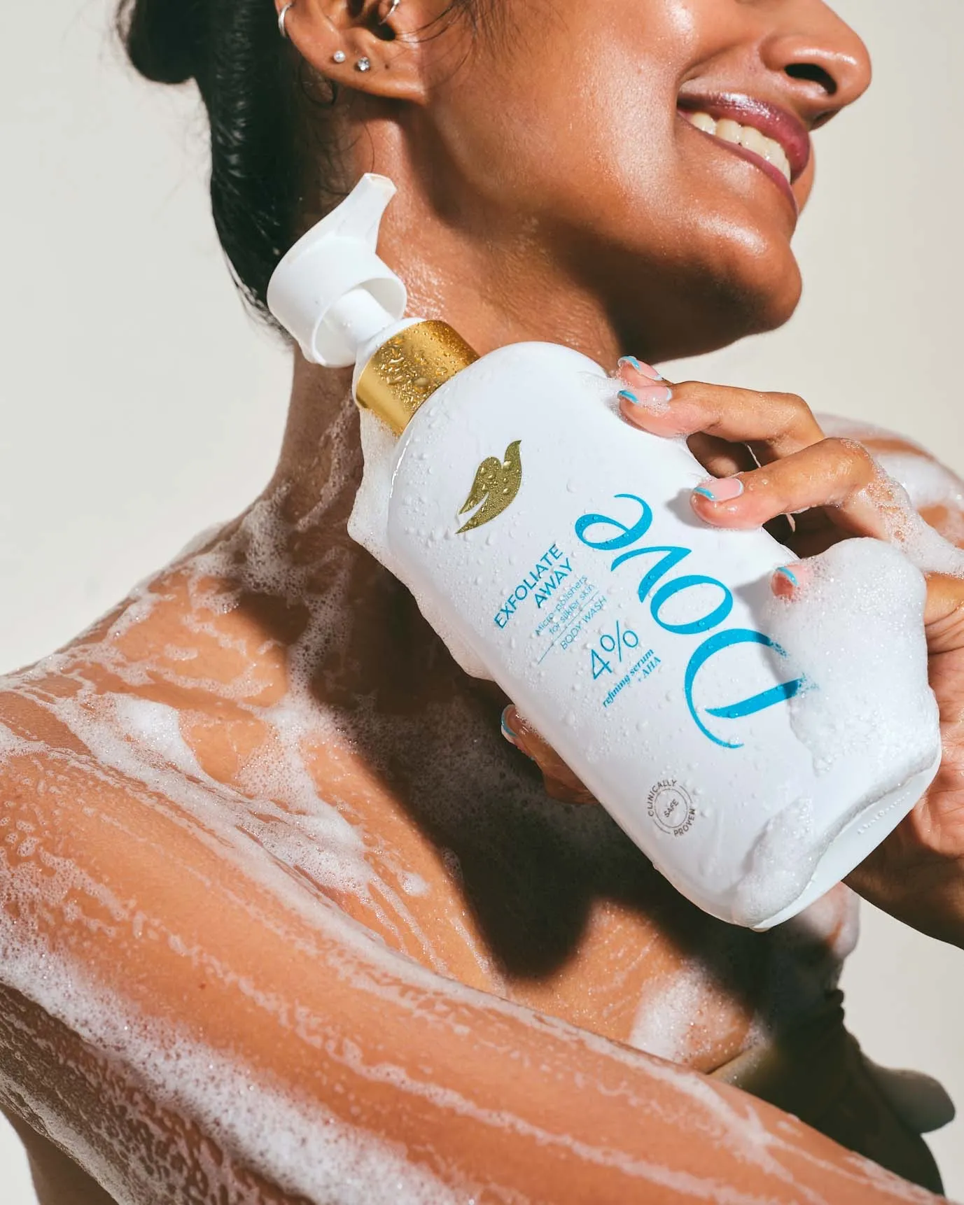 A woman in the shower and her body lathered by the Dove body wash as part of her body care routine
