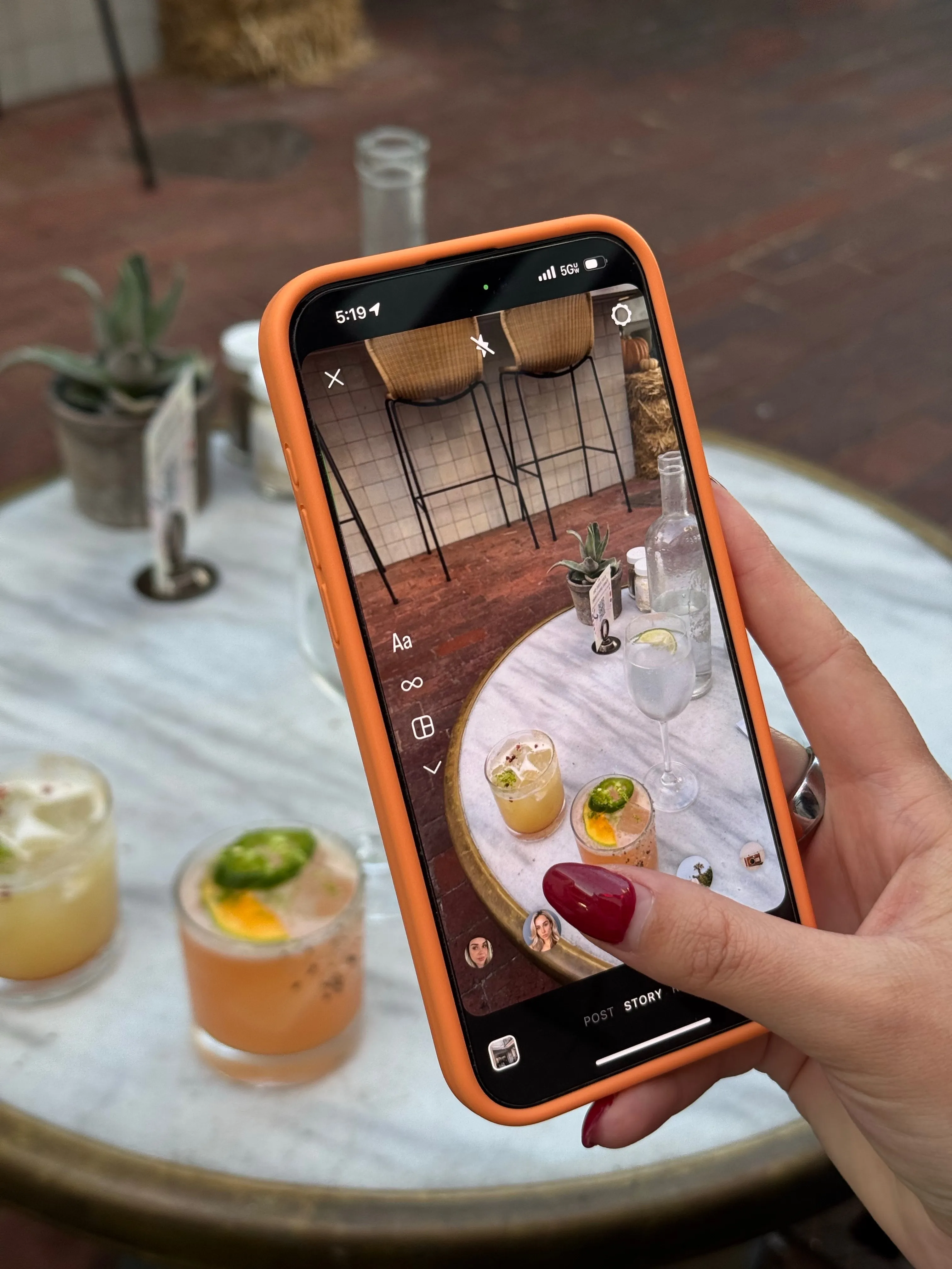 A woman taking a photo of her drink at a café, highlighting how hobbies often turn into social media content