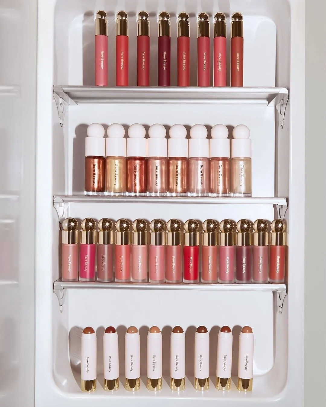 An image of multiple make-up products including contour sticks from Rare Beauty