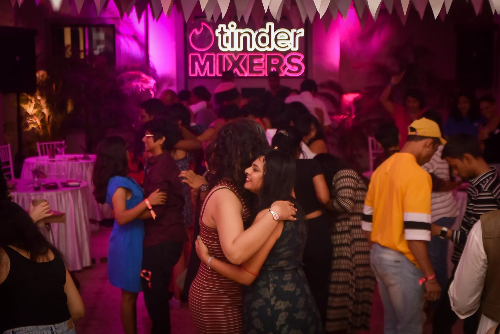Two women hug each other at a single's mixer to show how mixers could work as solutions to challenges queer people face in dating besides using dating apps for LGBTQ in India