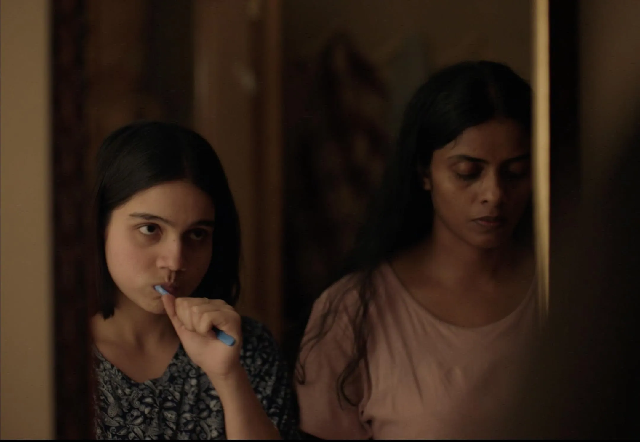 Two women-a mother and daughter-brushing their teeth as they stand in front of the mirror to show the growing representation of female desire in Bollywood, and how MUBI India indie films are changing the concept of taboo romance films