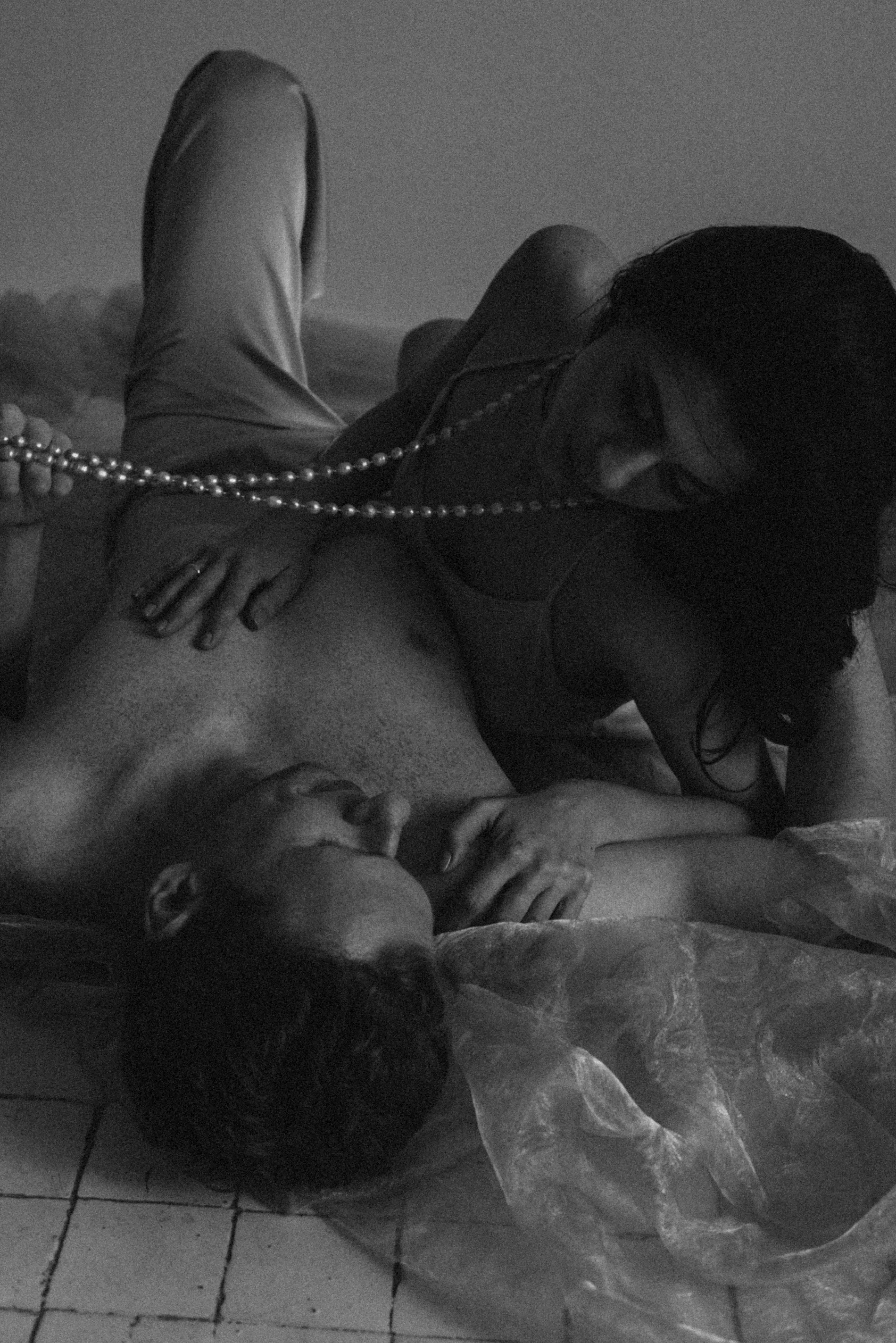 A black and white picture of a man and woman laying down and getting intimate to show how modern dating in India is impacted by emotional labour in relationships which define the two types of boyfriends in India.