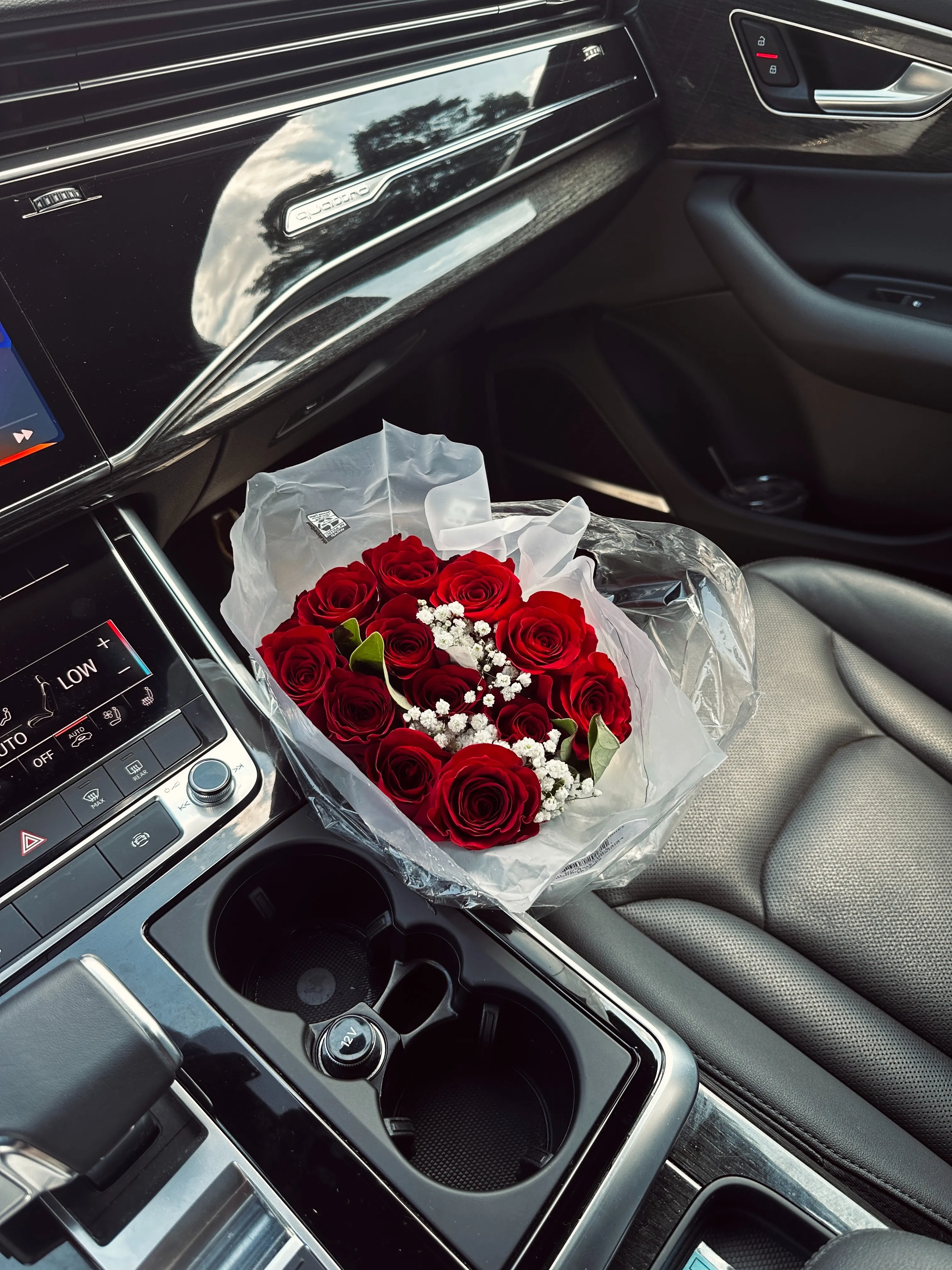 A picture of a cubby in a car containing a bouquet of roses as a means of depicting the space gestures like giving flowers take up in modern dating in India, given that there are two types of boyfriends in India, one of which believes in grand gestures and the other that doesn't.