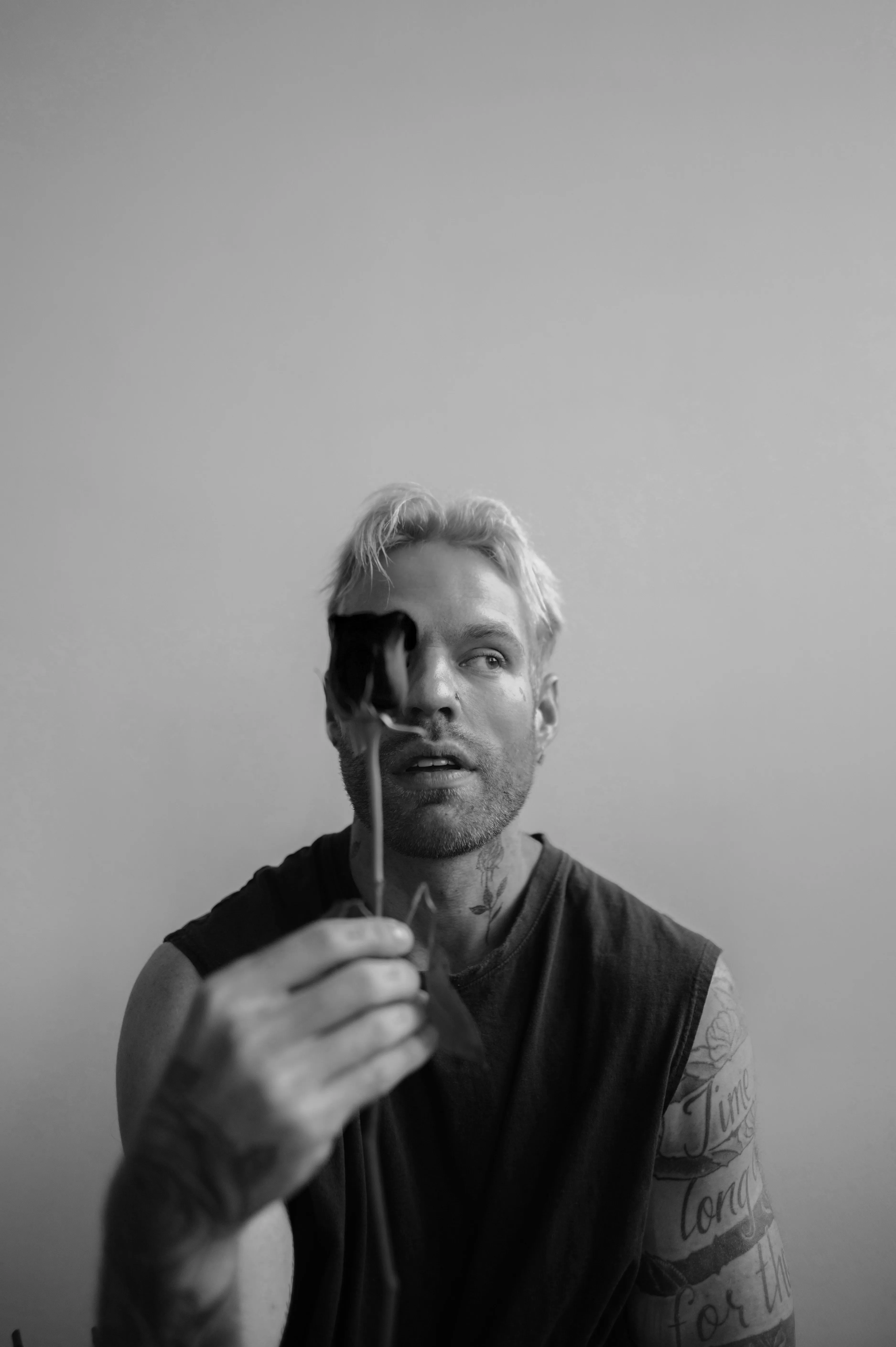 A black and while picture of man holding up a rose to depict the load of emotional labour in relationships, which is defining modern dating in India as well as relationship trends in India.