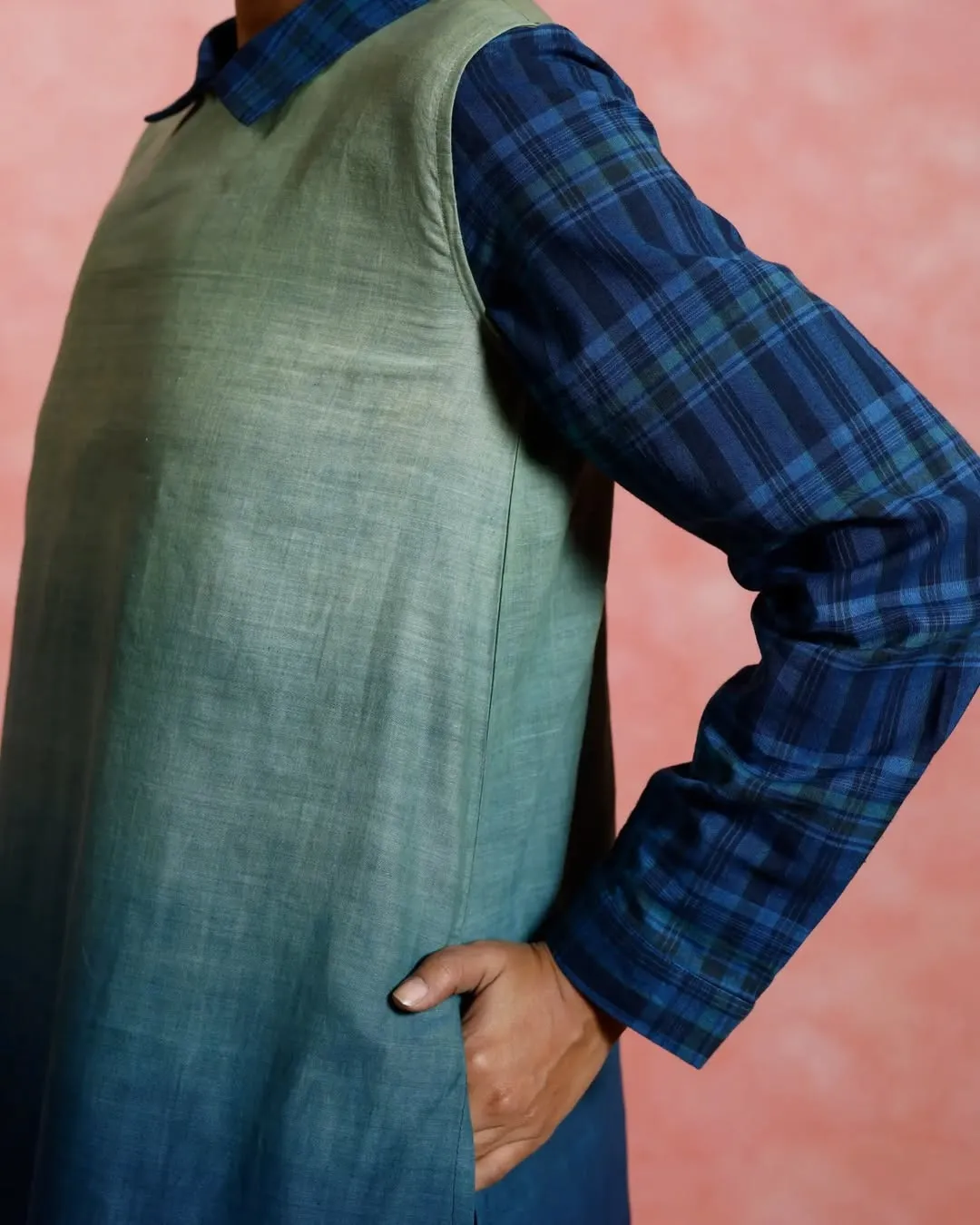 A picture of a person wearing a blue tunic made of Indian weave that is an epitome of the impact of immigration in India on Indian culture, depicting the importance of it in globalisation and culture, and hence the importance of the current anti immigration protests.