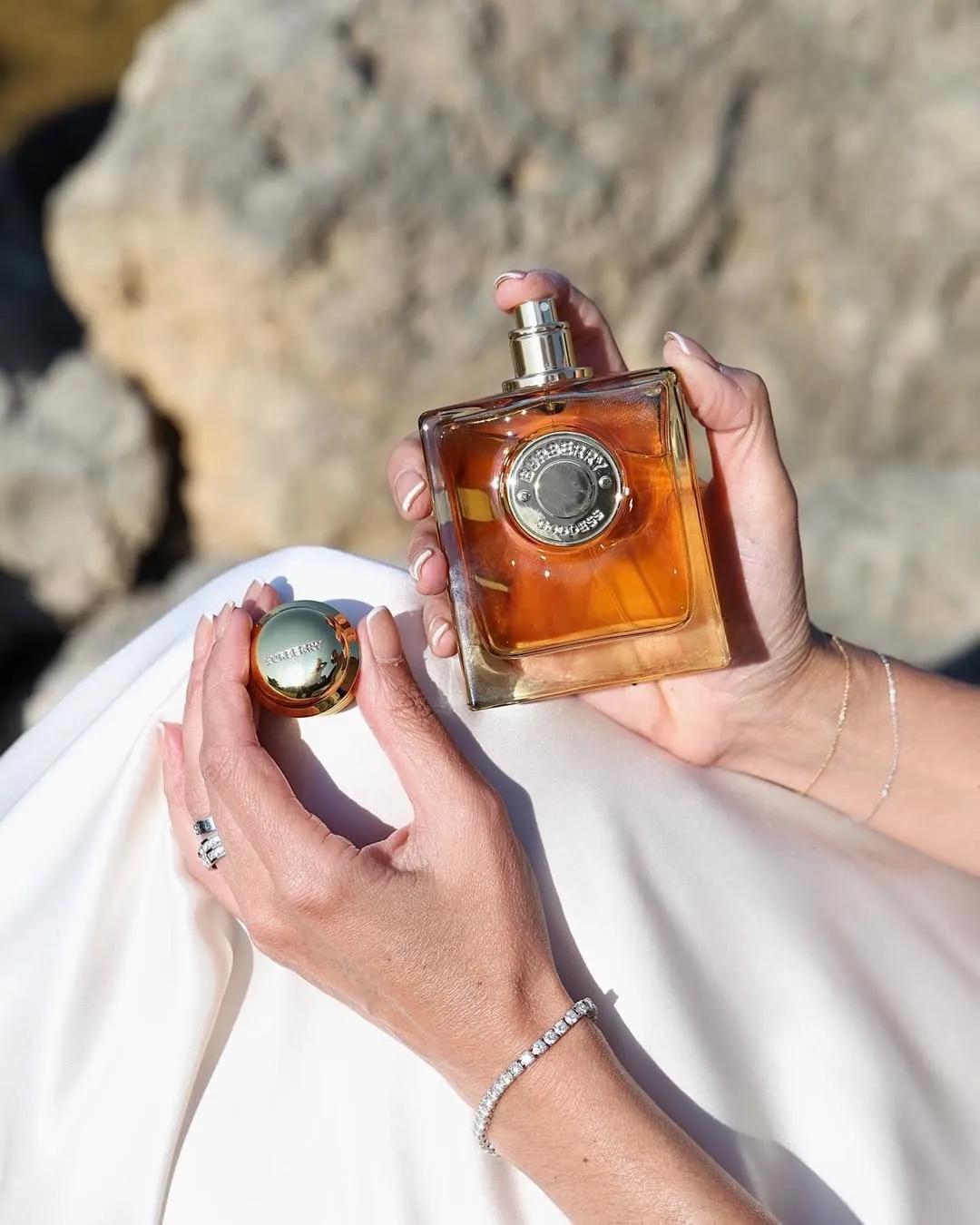 Burberry Goddess vanilla perfume in a woman's hand with diamond jewellery
