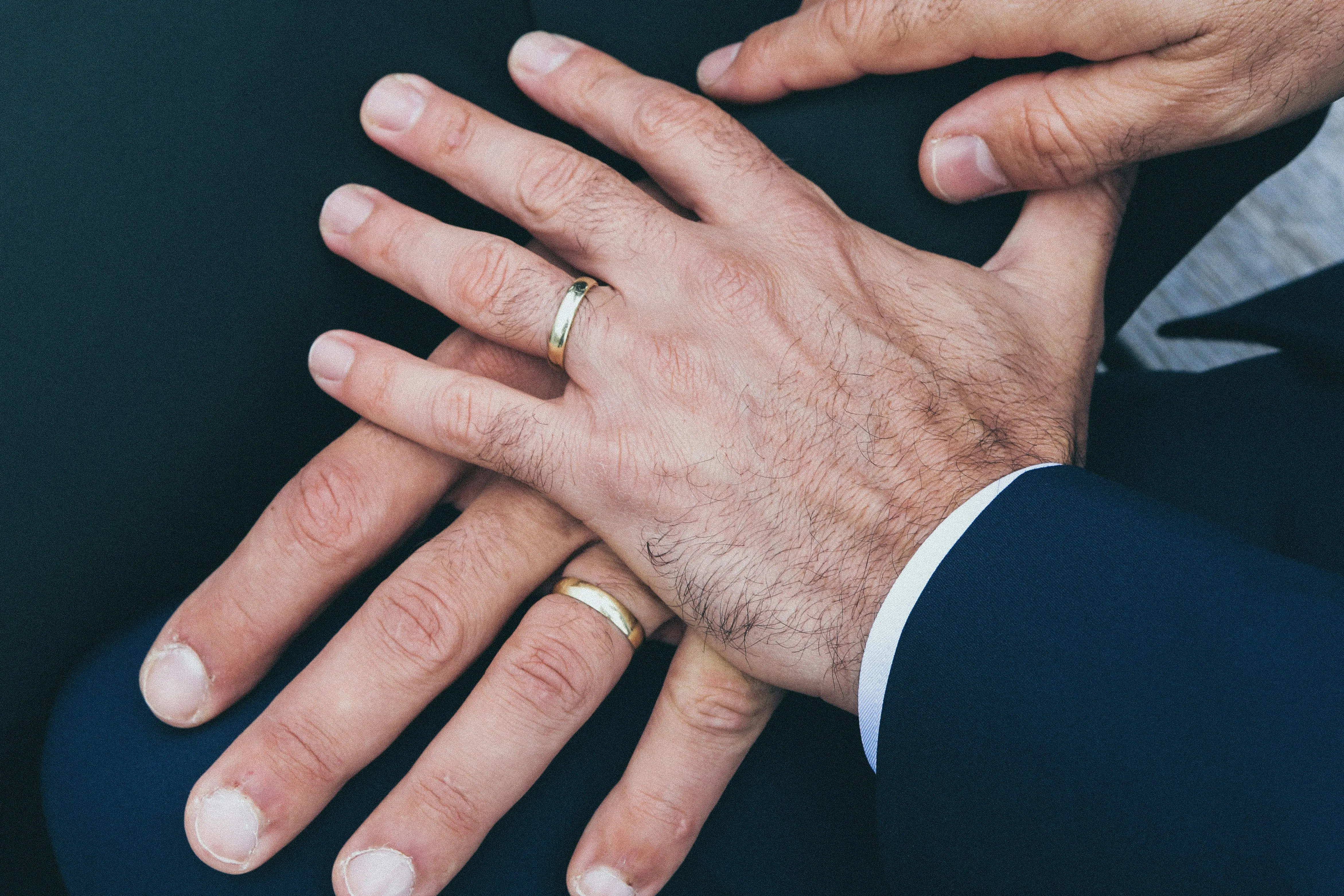 A picture of two male hands wearing rings on their wedding ring finger to show how queer parenthood legal rights and queer parenting in India are becoming a reality despite hurdles