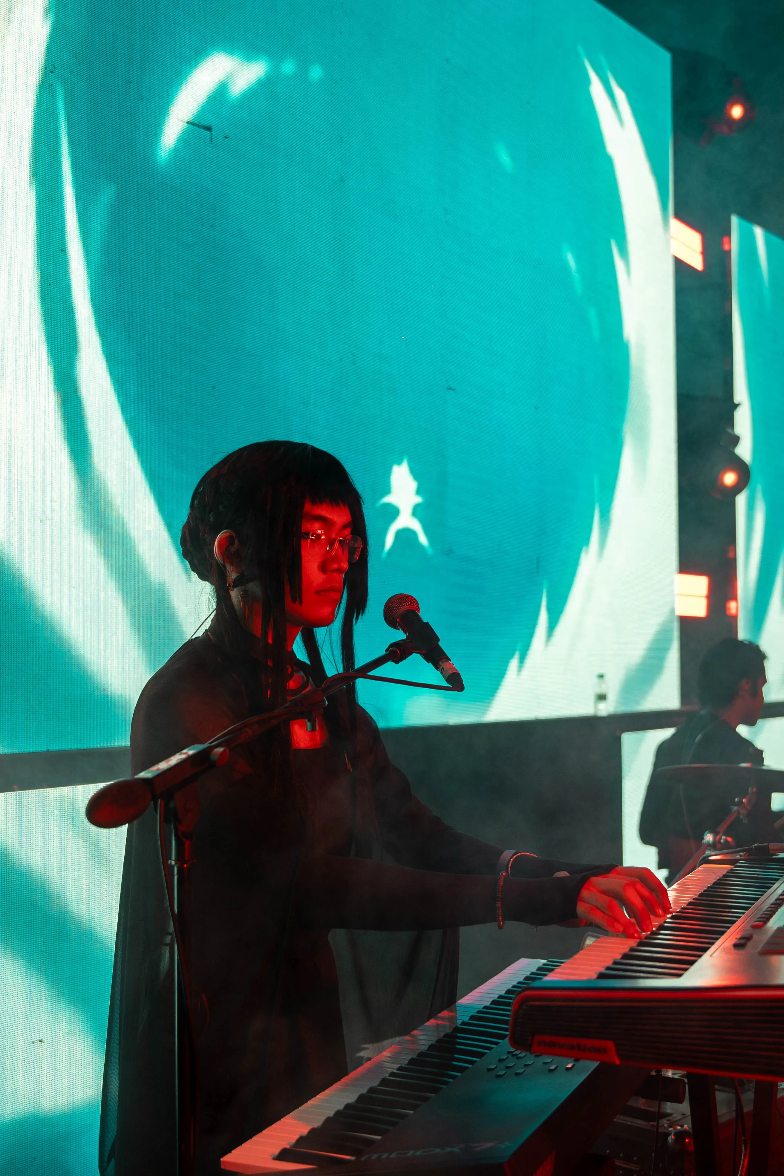 A picture of a musician playing the keyboard while wearing an anime cosplay outfit to showcase how Asian influence in India has spread via anime
