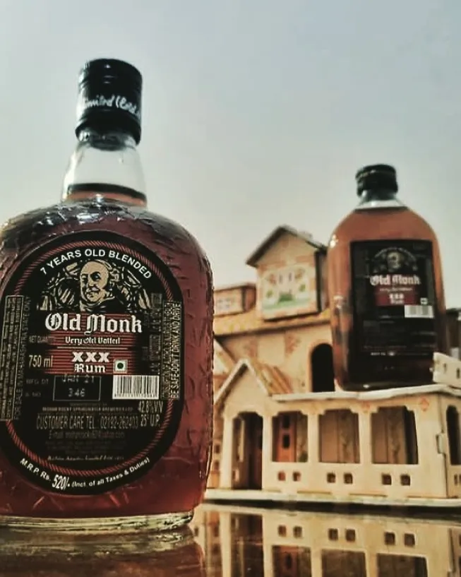 A picture of two bottled of Old Monk rum against a fort-type background, to depict how it's one of the oldest Indian rum brands that became extremely popular, and was also considered the best rum in India for the longest time.
