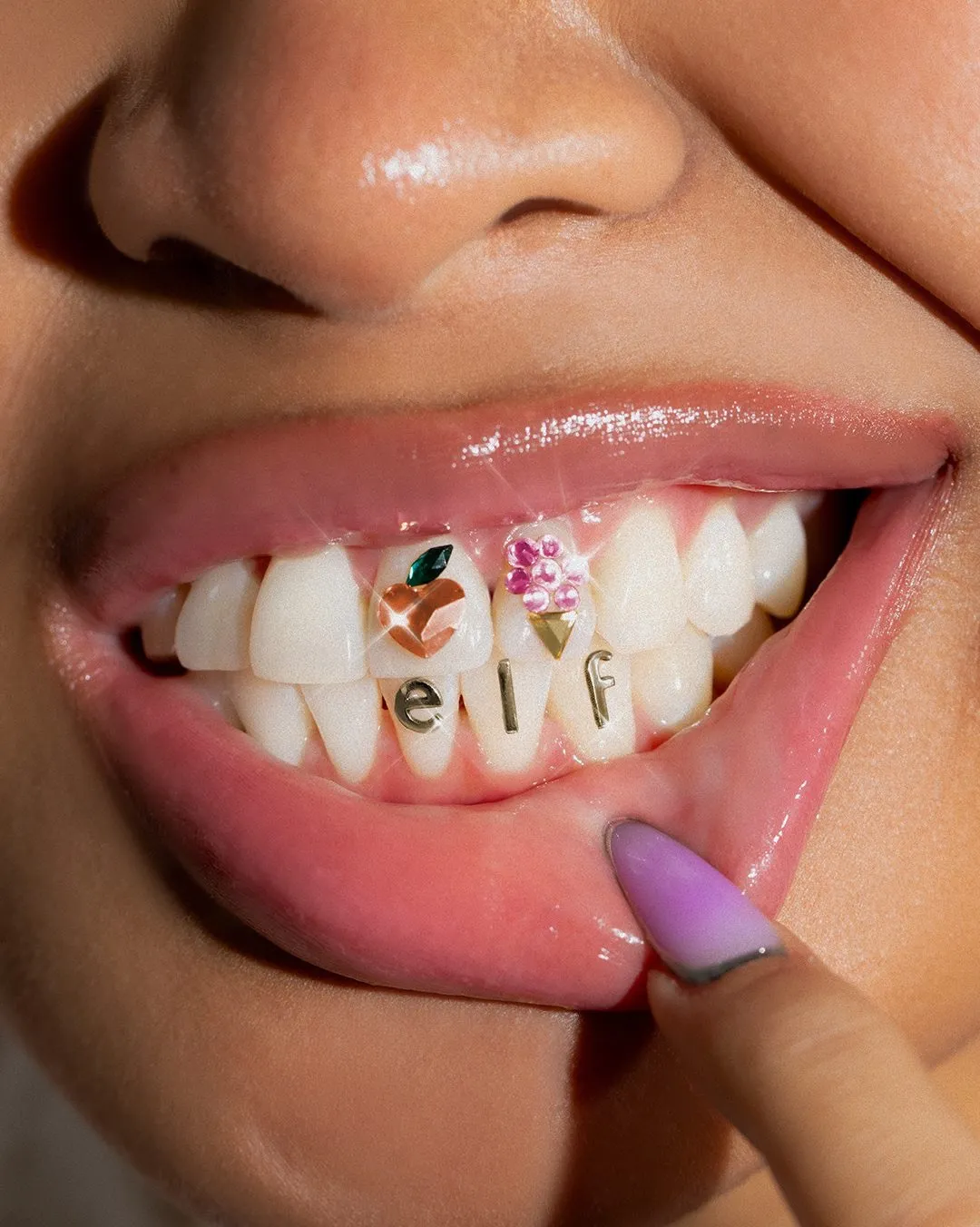 A picture of a woman's teeth, with elf encrusted on them, suggesting how hype marketing works in the beauty industry in India