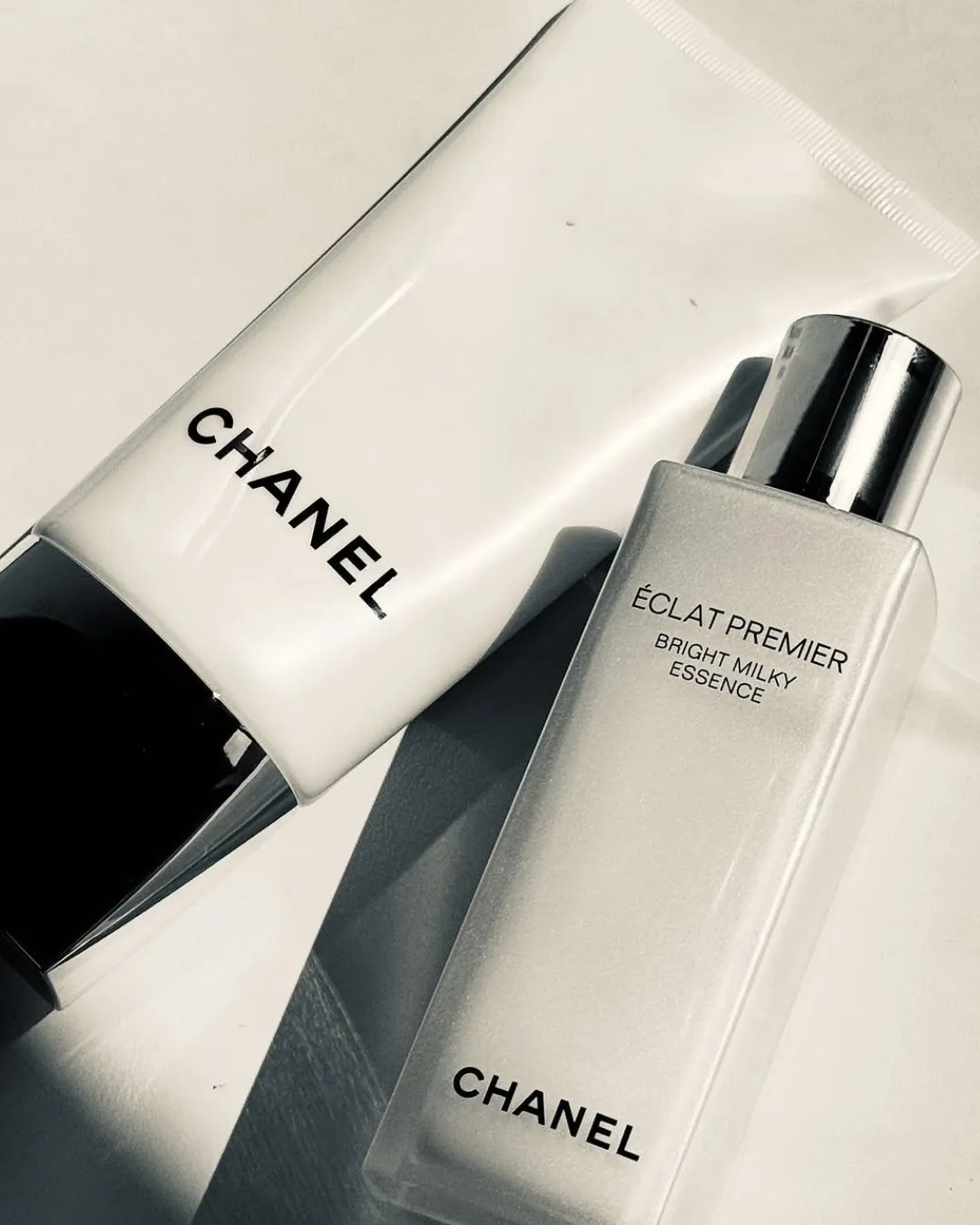 A bottle of Chanel's milky toner placed next to a primer tube from the brand
