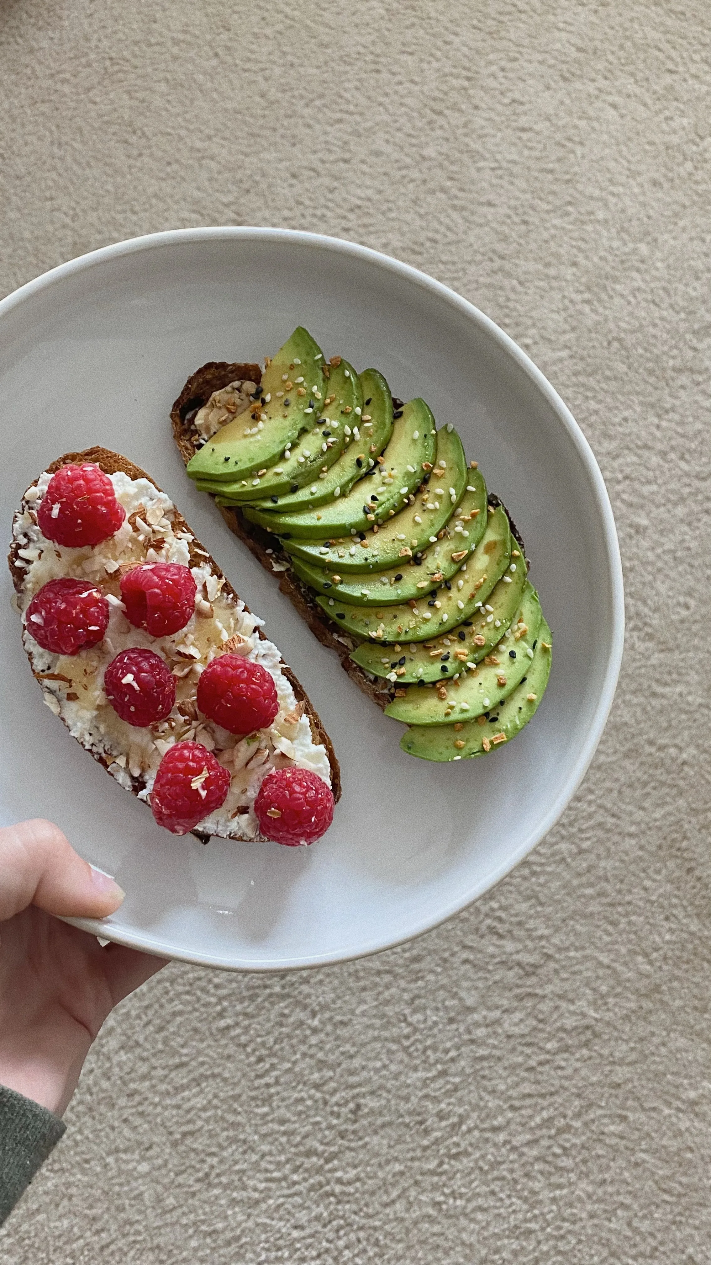 A plate with berry-cheese and avocado toasts
