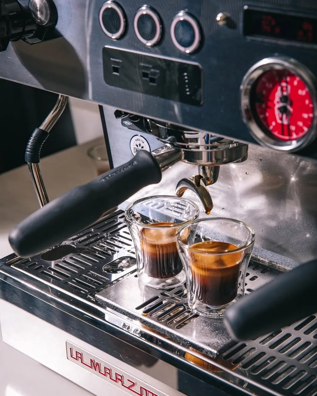 A picture of a coffee maker with two cups of freshly ground and freshly roasted coffee to show the rise of luxury coffee brands in India with homegrown artisanal coffee India with brands like Araku