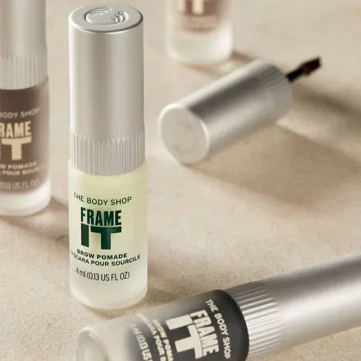 Two eyebrow gels from The Body Shop placed on a marble surface