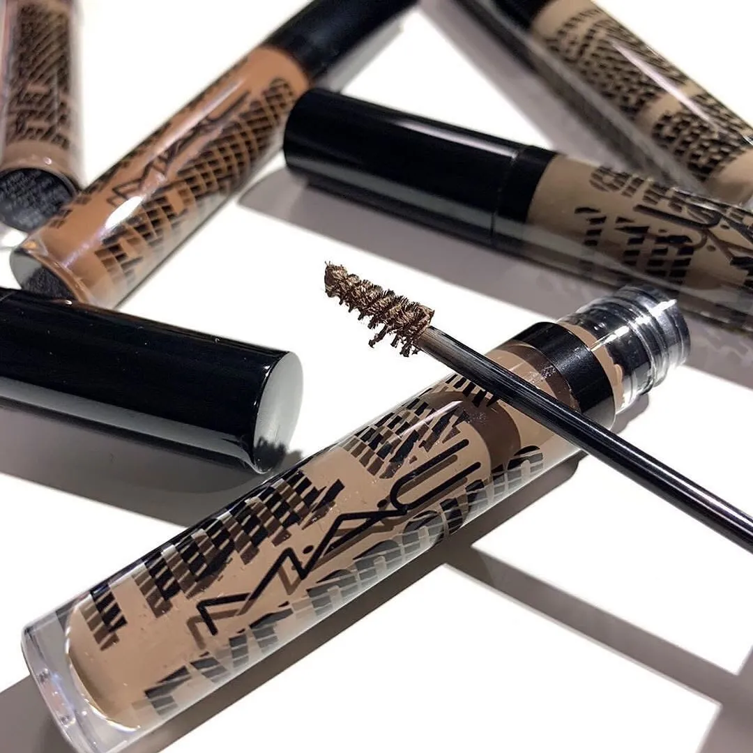 A flatlay shot of some tinted eyebrow gels from M.A.C placed on a white surface