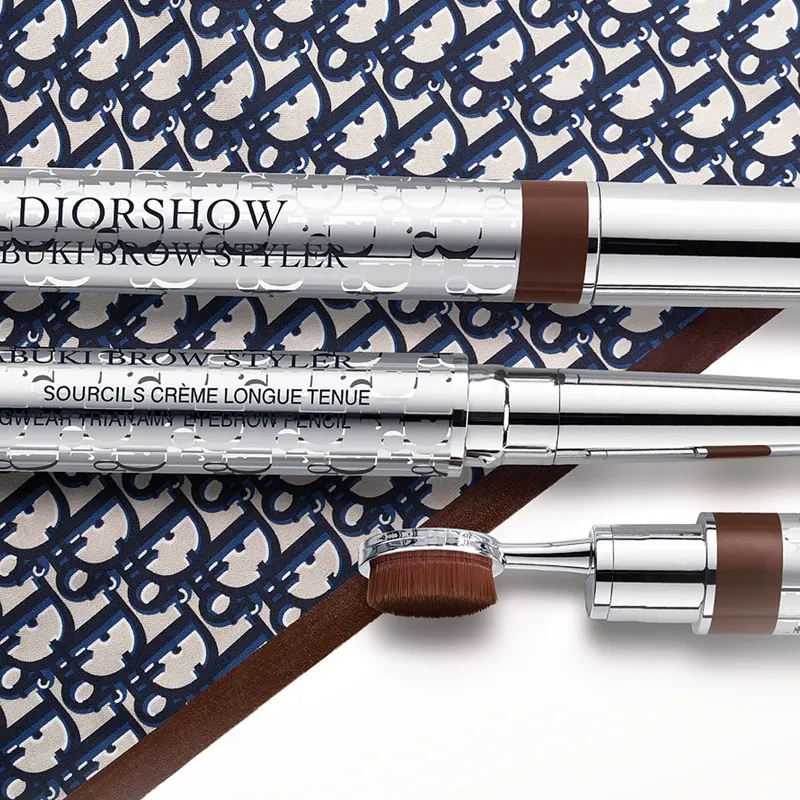 Eyebrow pencil with brush from Dior Beauty placed on a surface with Dior's logo
