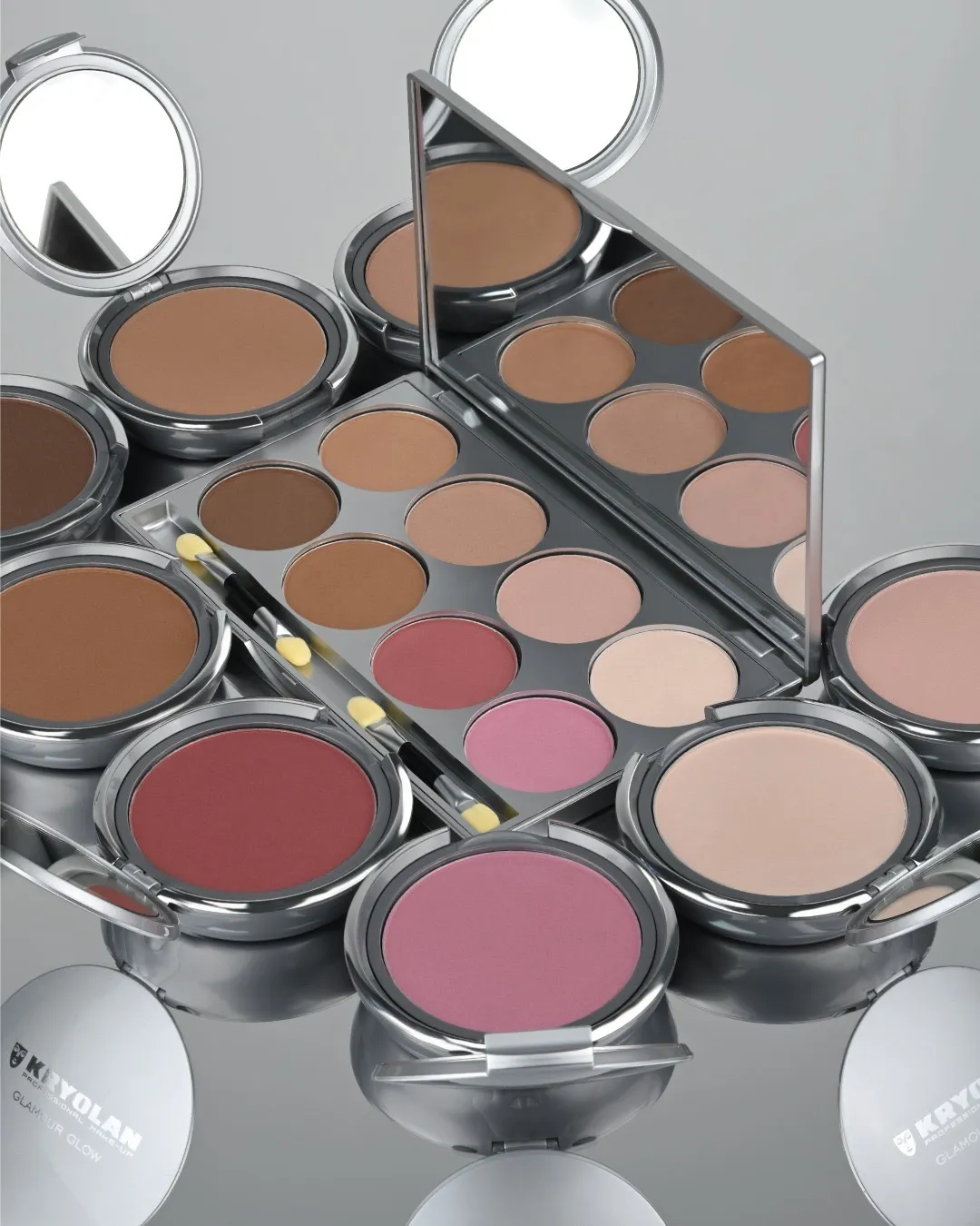 A few pans of make-up palettes placed on a silver tray, including highlighter powder too