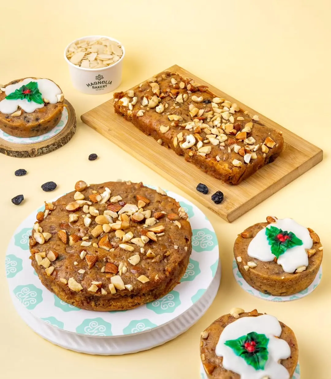 Magnolia Bakery India’s Christmas plum cakes and festive mini loaves topped with nuts and icing, displayed on a pastel background