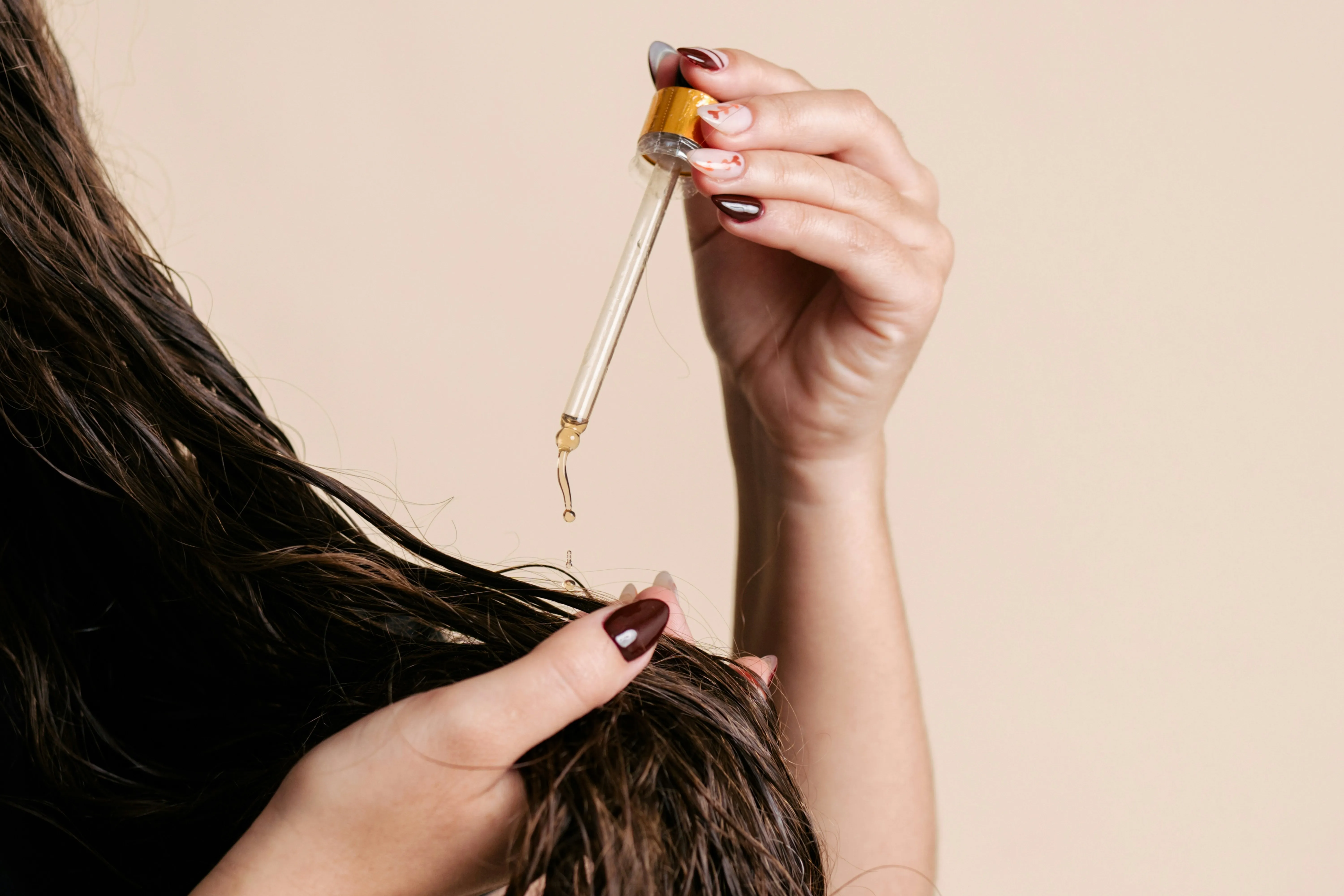 A woman applying hair growth products on her hair strands