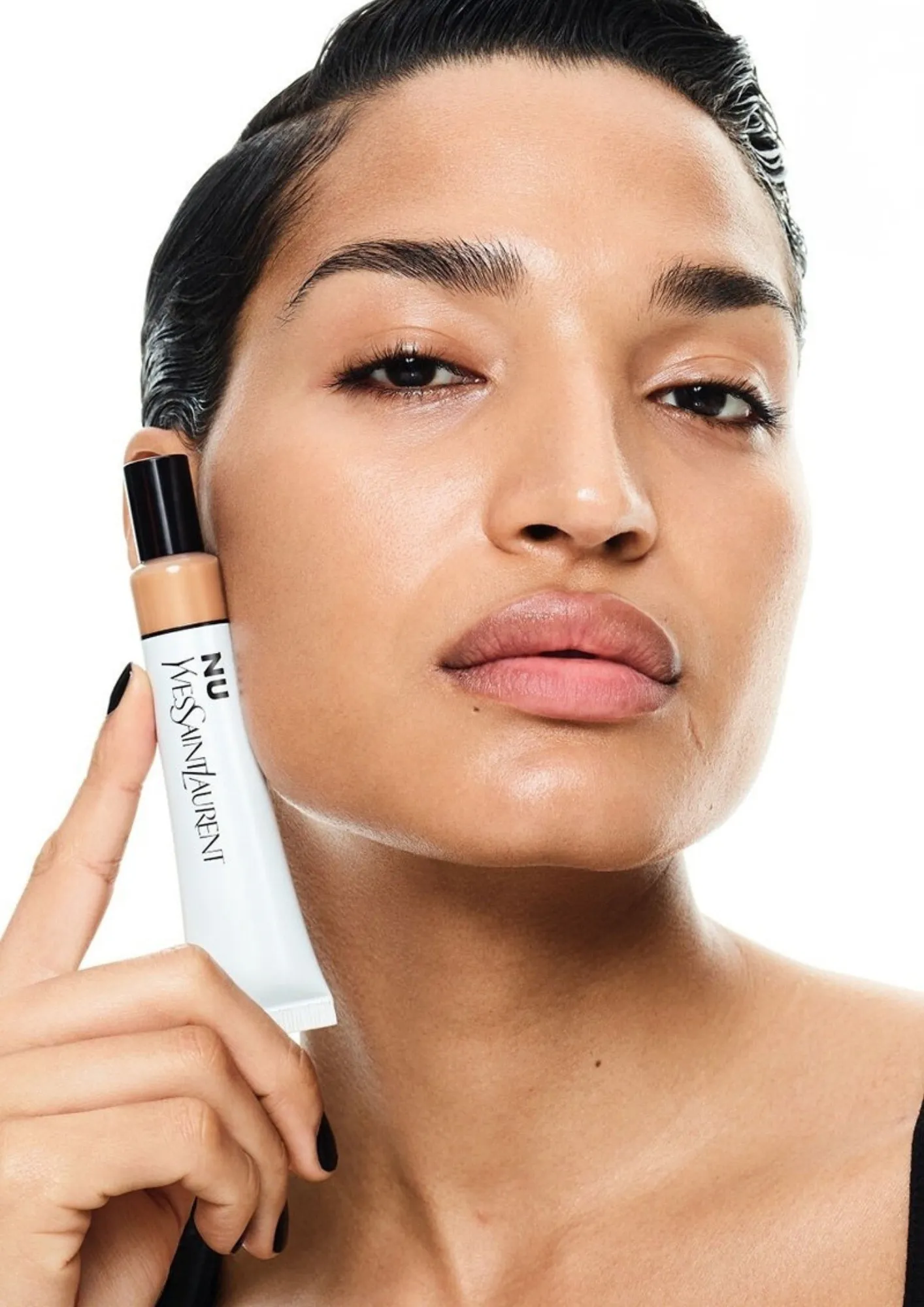 A female model with a skin tint held close to her skin