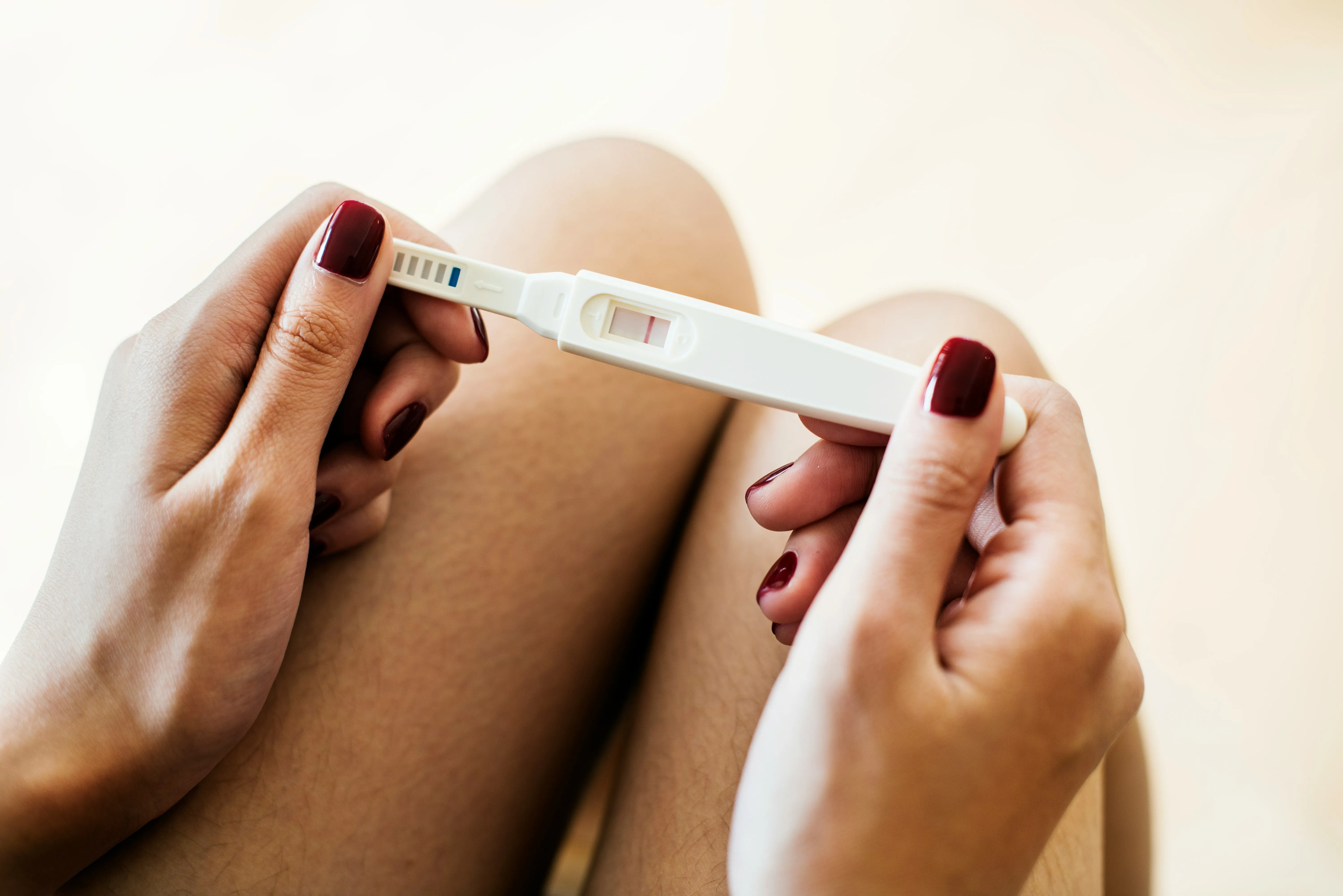 A woman holding a pregnancy test wand in her hand