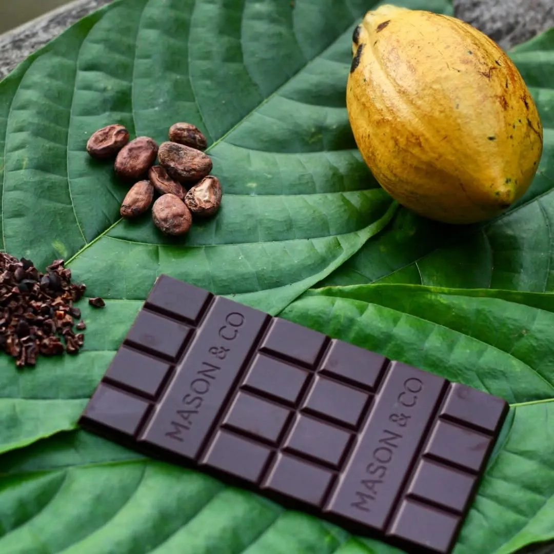 A picture of a bar of Mason and Co chocolate with cacao beans around to show how Indian chocolate brands are acing the market for artisanal chocolate India
