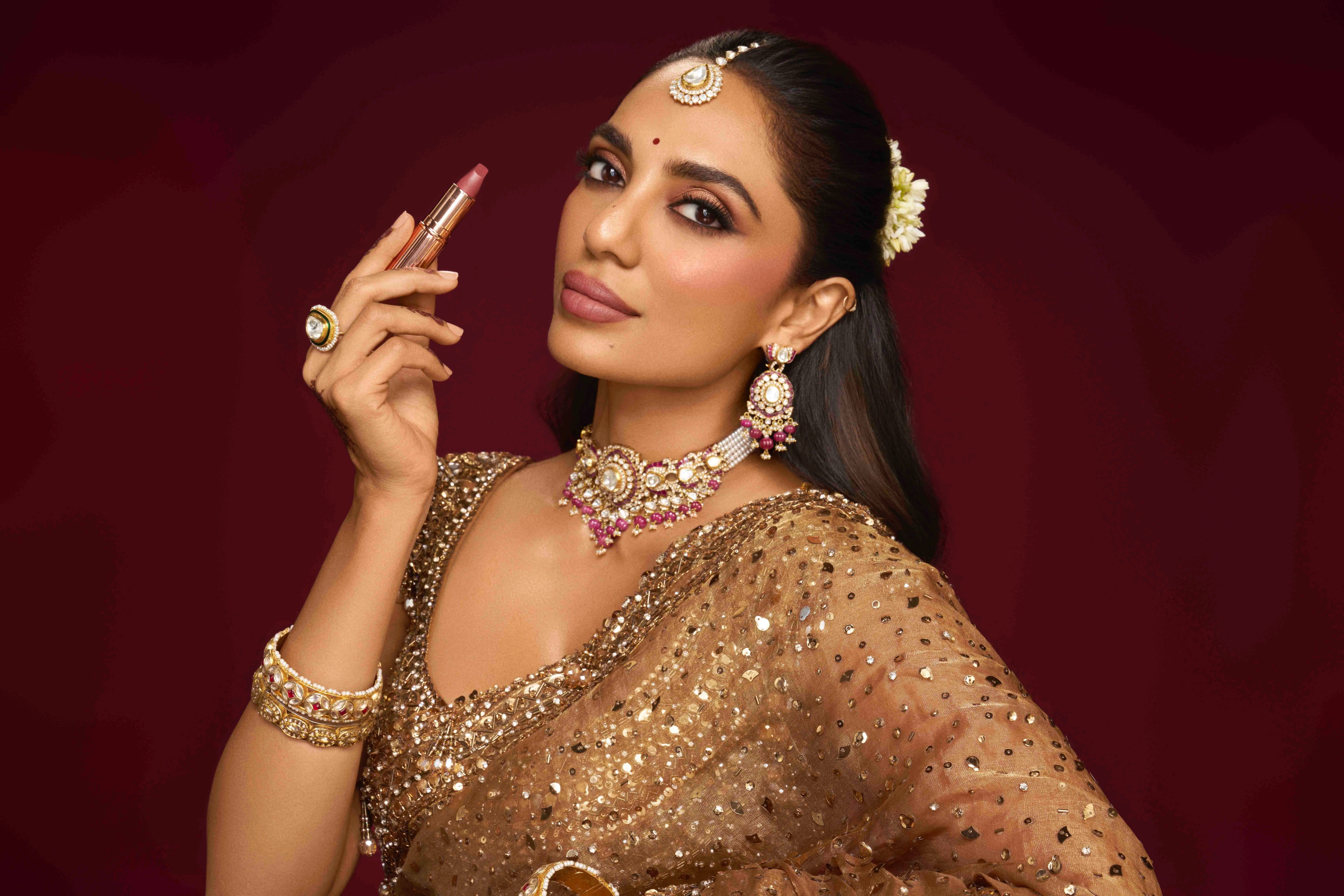 Shobhita Dhulipala with a Charlotte Tilbury lipstick in hand, perfect for bridal make-up