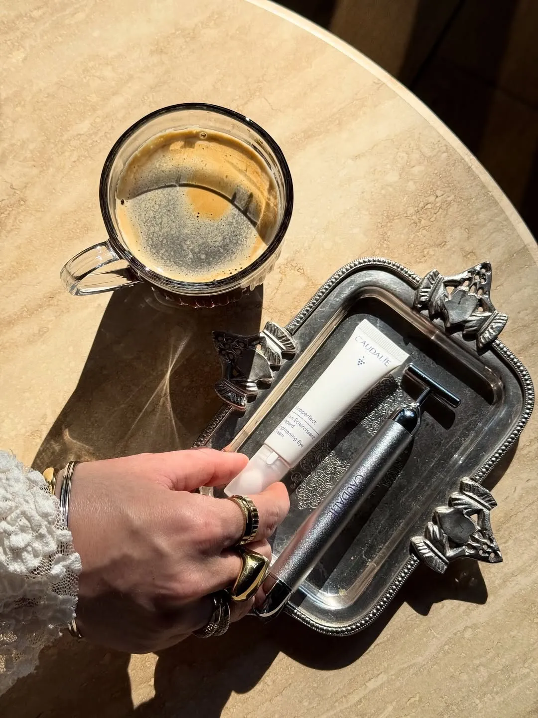 The best under eye cream for dark circles and puffiness from Caudalie placed on a tray with coffee