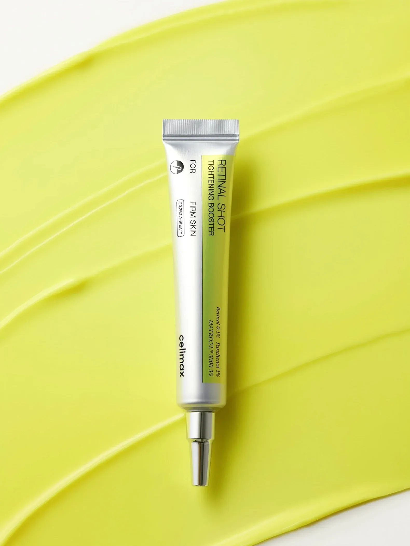A tube of the best Korean under eye cream placed on a smear of the green-coloured cream