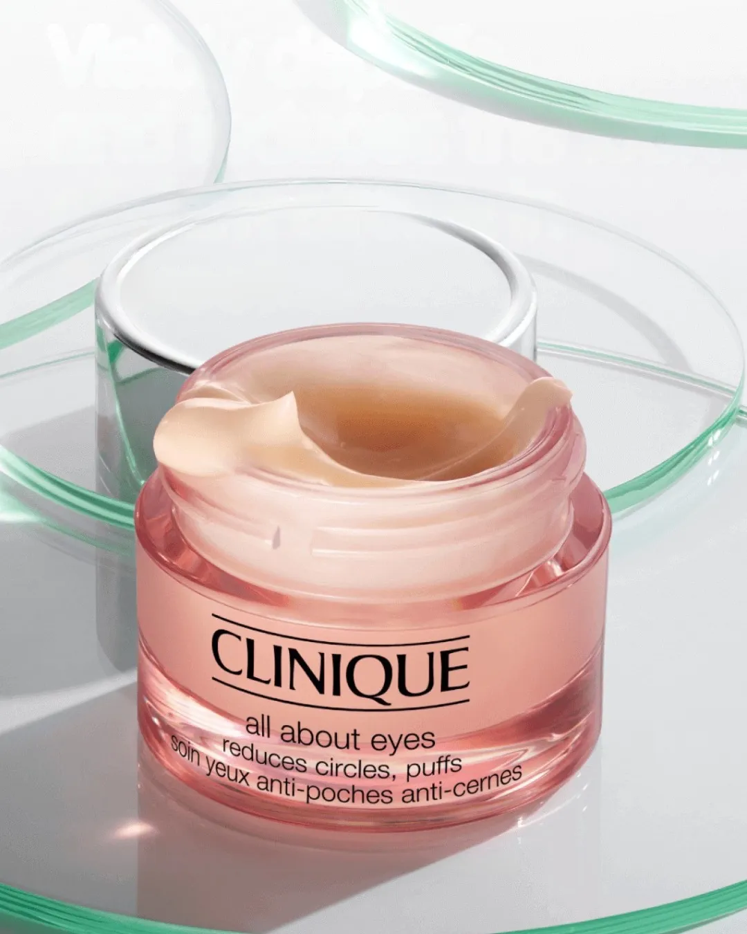 A jar of best hydrating cream for under eyes from Clinique placed on glass trays