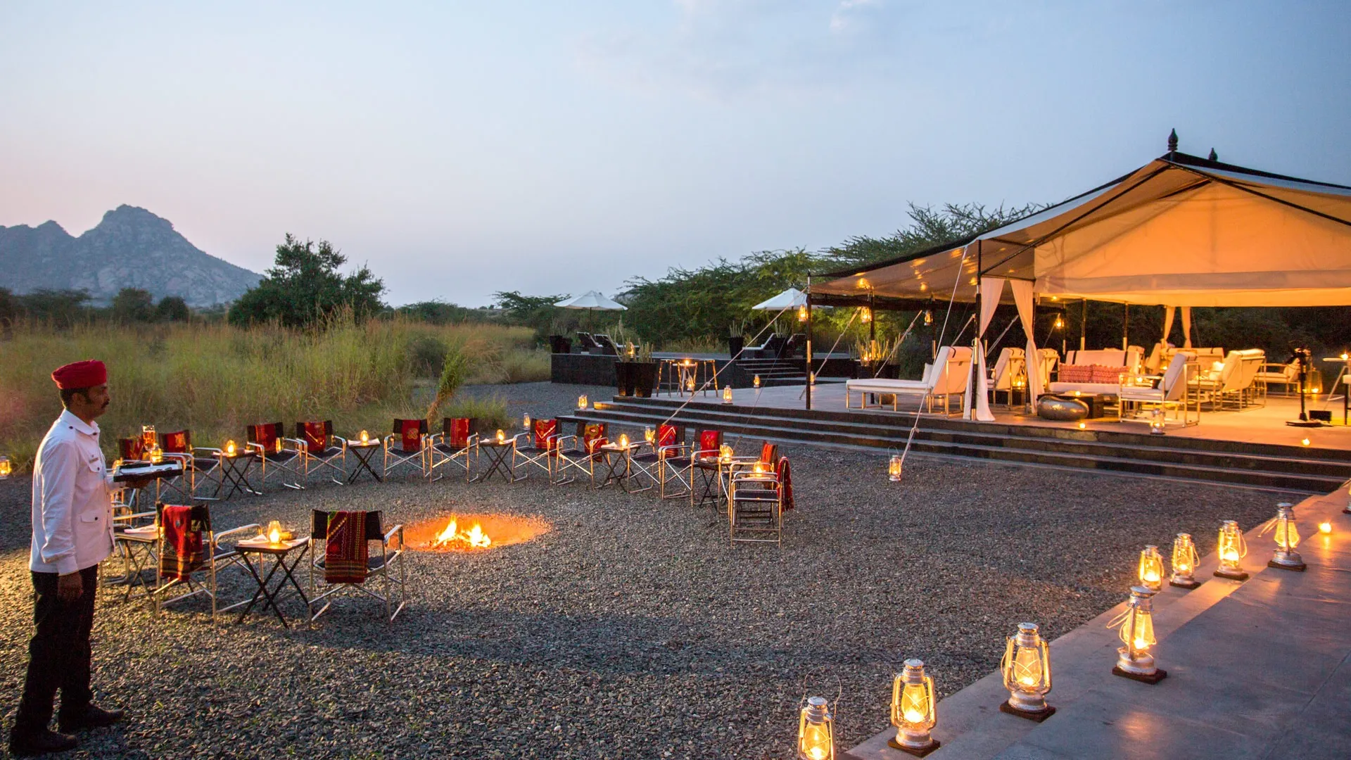 An open-air wilderness camp dining setup showcasing responsible luxury tourism through low-impact hospitality and immersive natural settings.