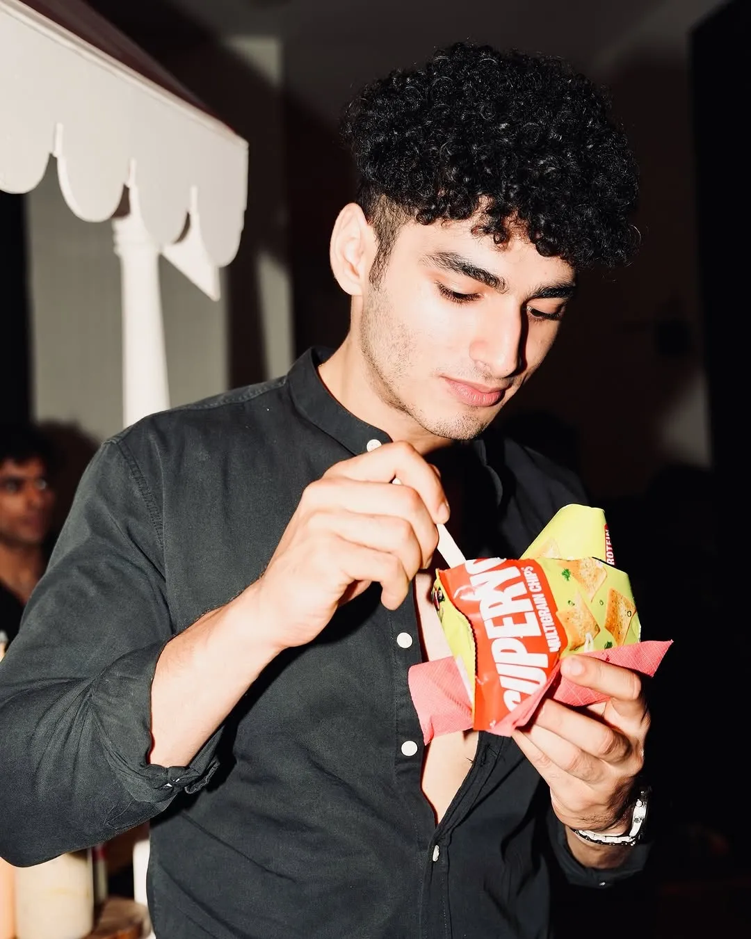 A picture of guy eating chips from a packet of SuperYou, a snack brand co-founded by Ranveer Singh