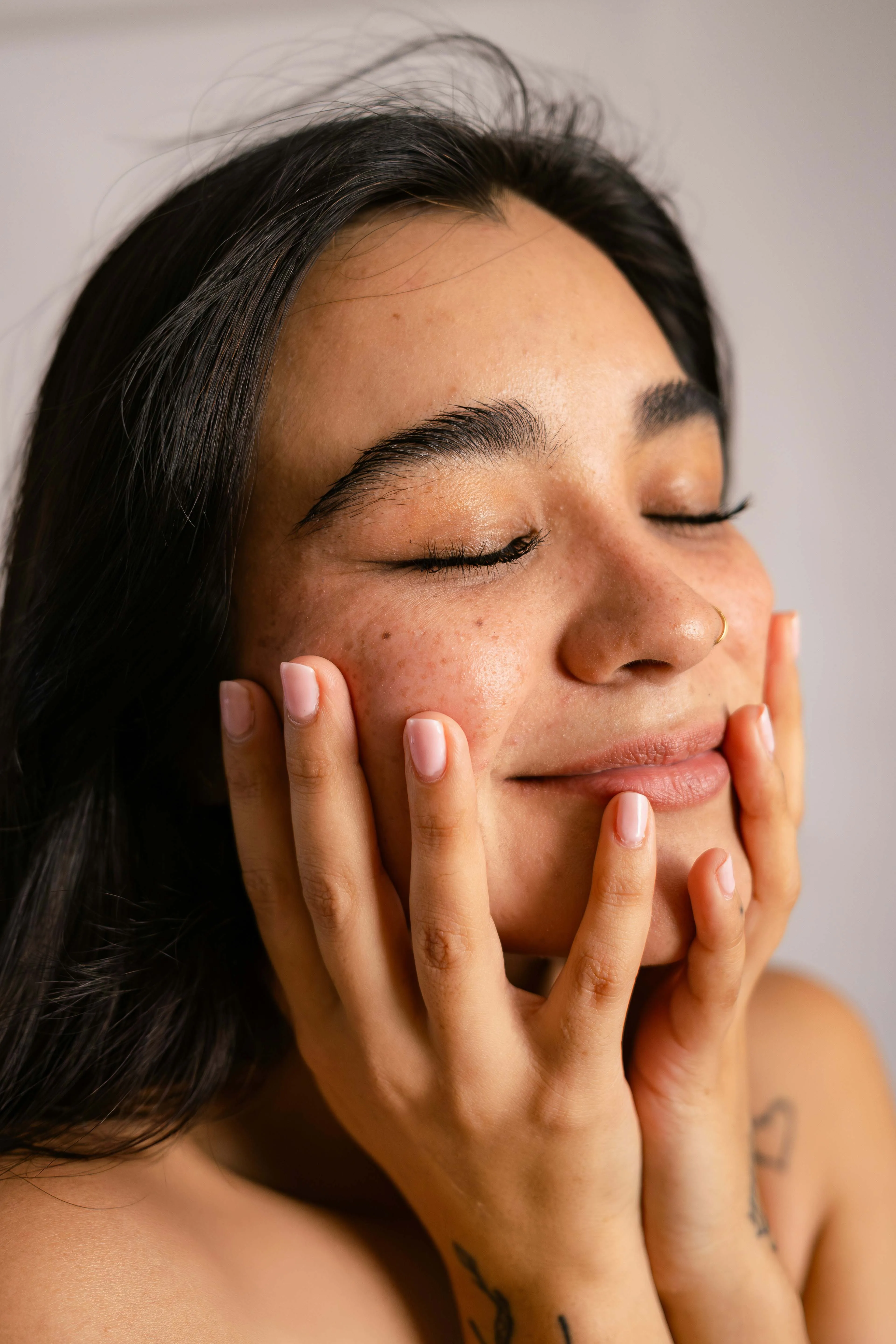 A zoomed-in photo of a woman's face with no make-up, just skincare on