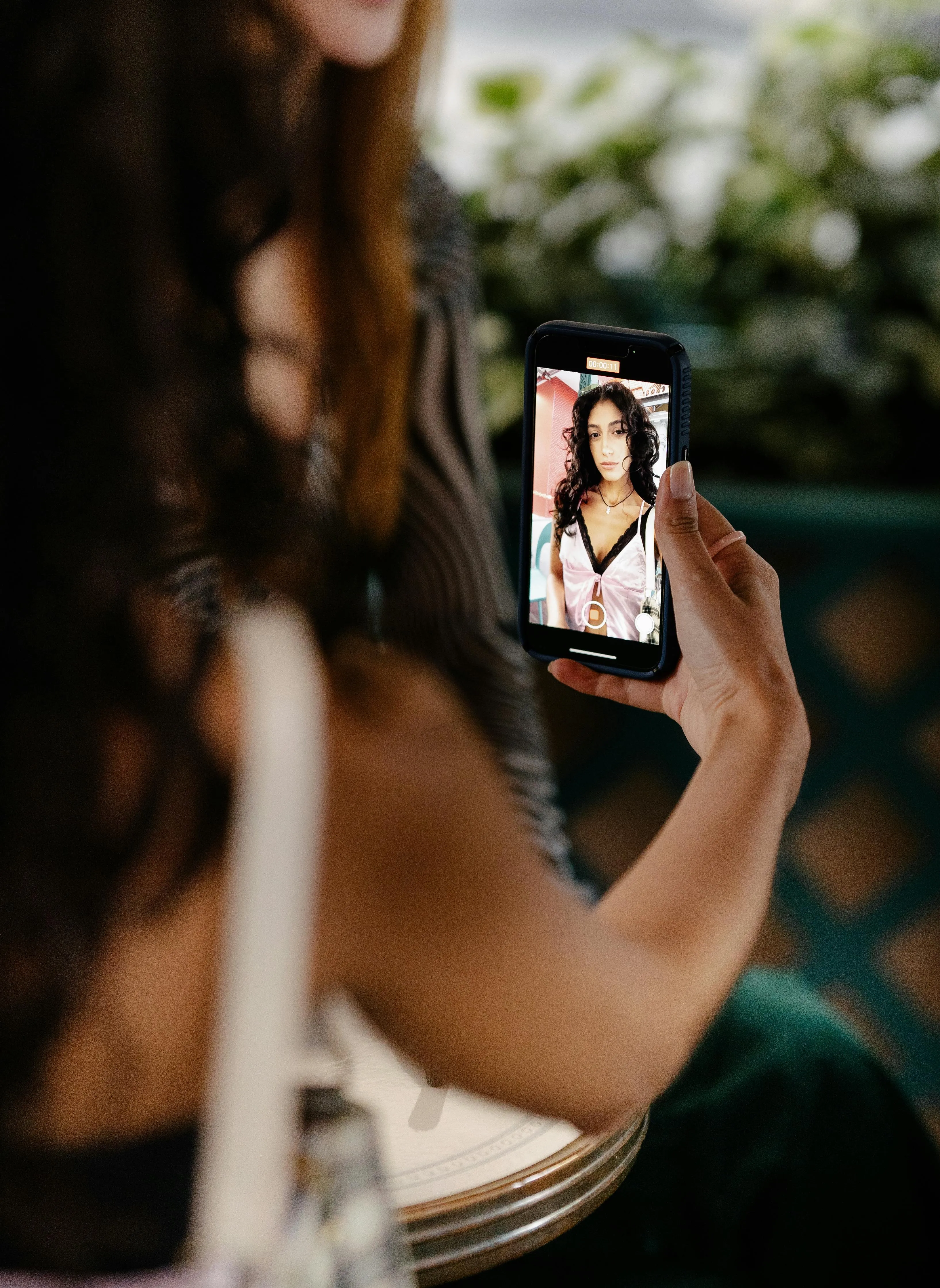 A woman taking a selfie in her mobile phone and analysing her face