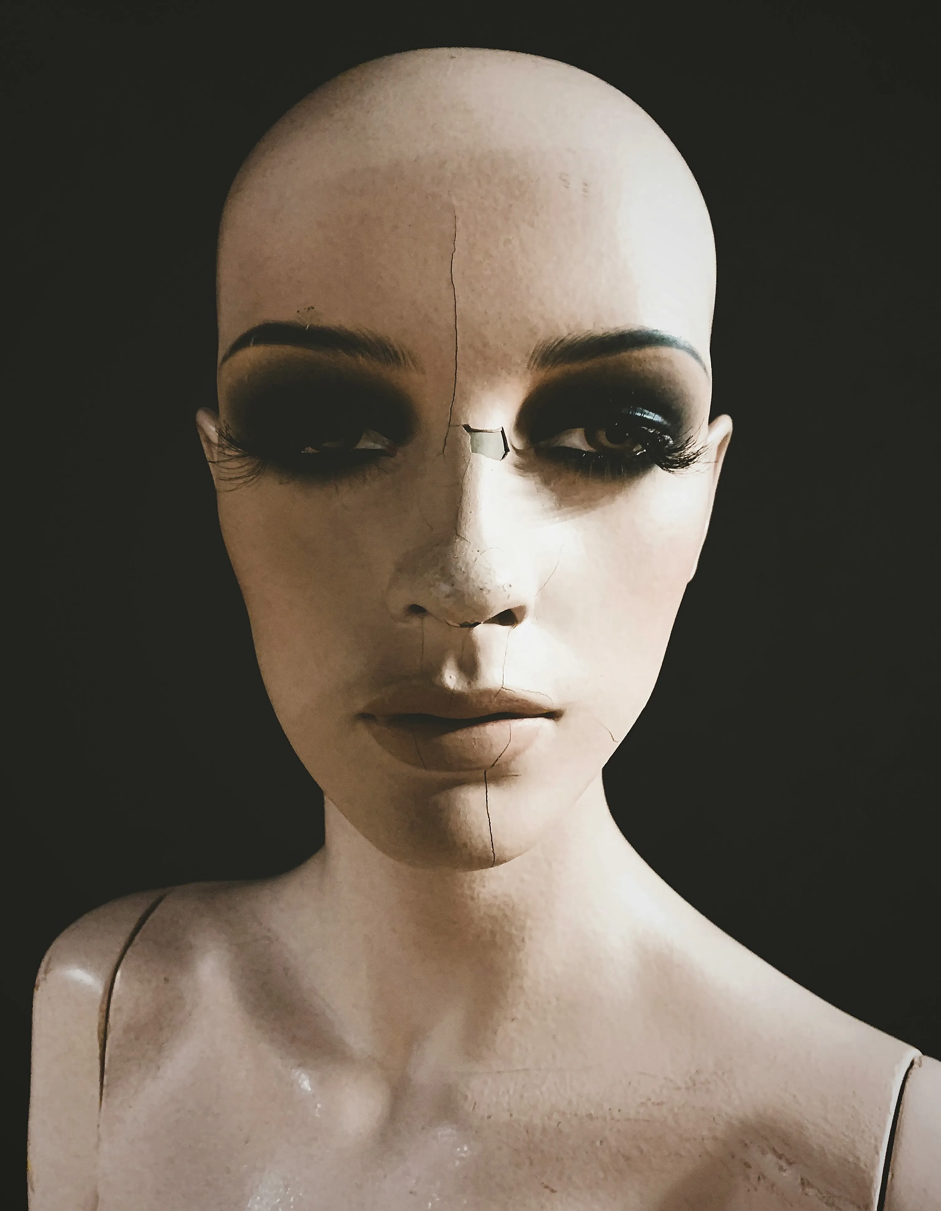 A zoomed in photo of a female mannequin with smokey eyes
