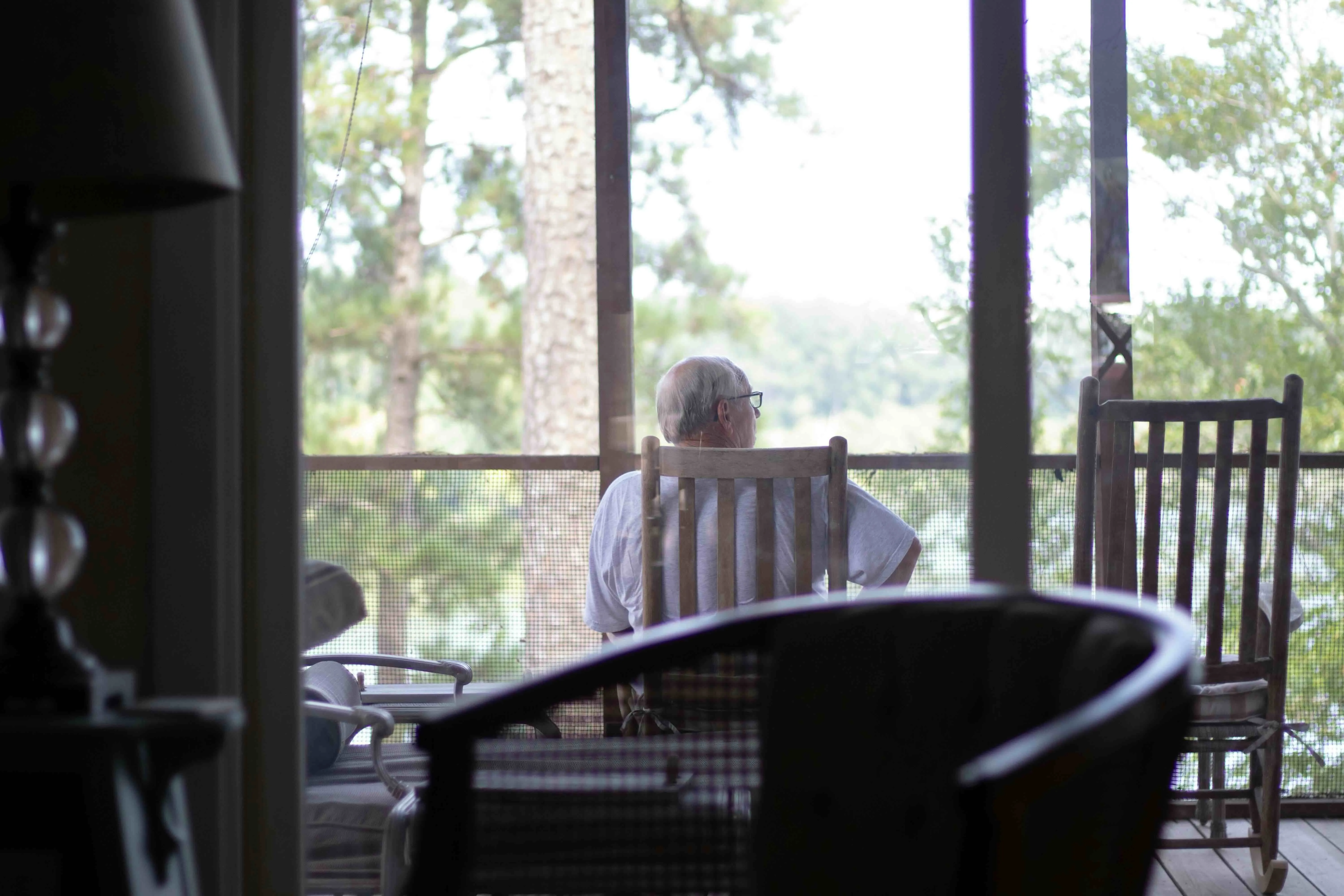 An elderly person sits alone on a porch to show queer ageing in India, loneliness among queer elders and ageing without marriage in India