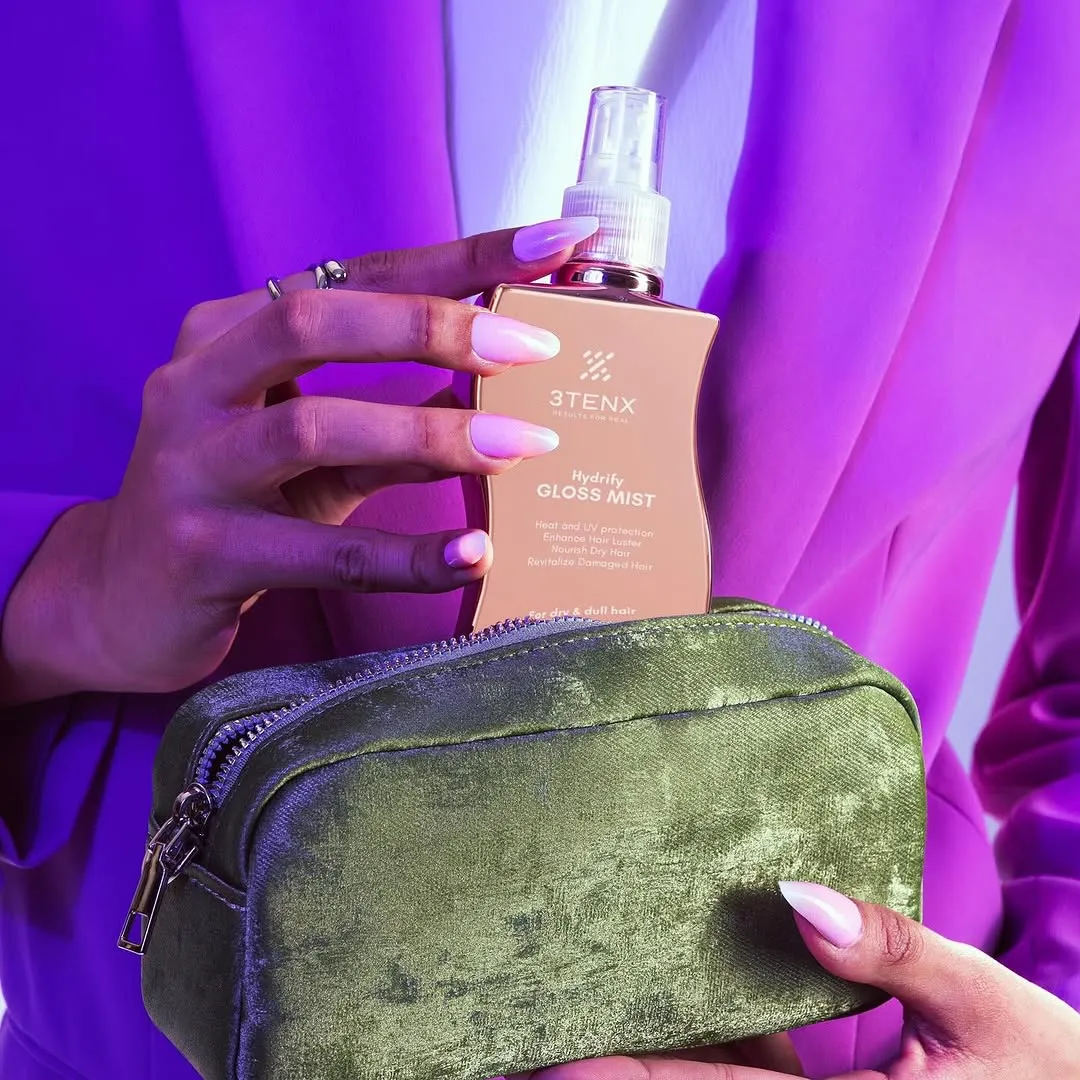 A bottle of hair spray for the best curly hair products in a woman's hand