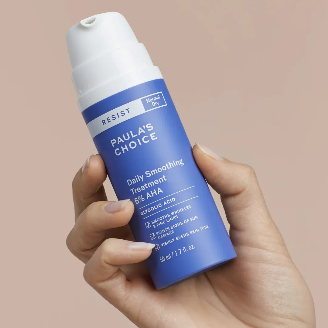 A bottle of Paula's Choice glycolic acid skin smoothing treatment in a woman's hand