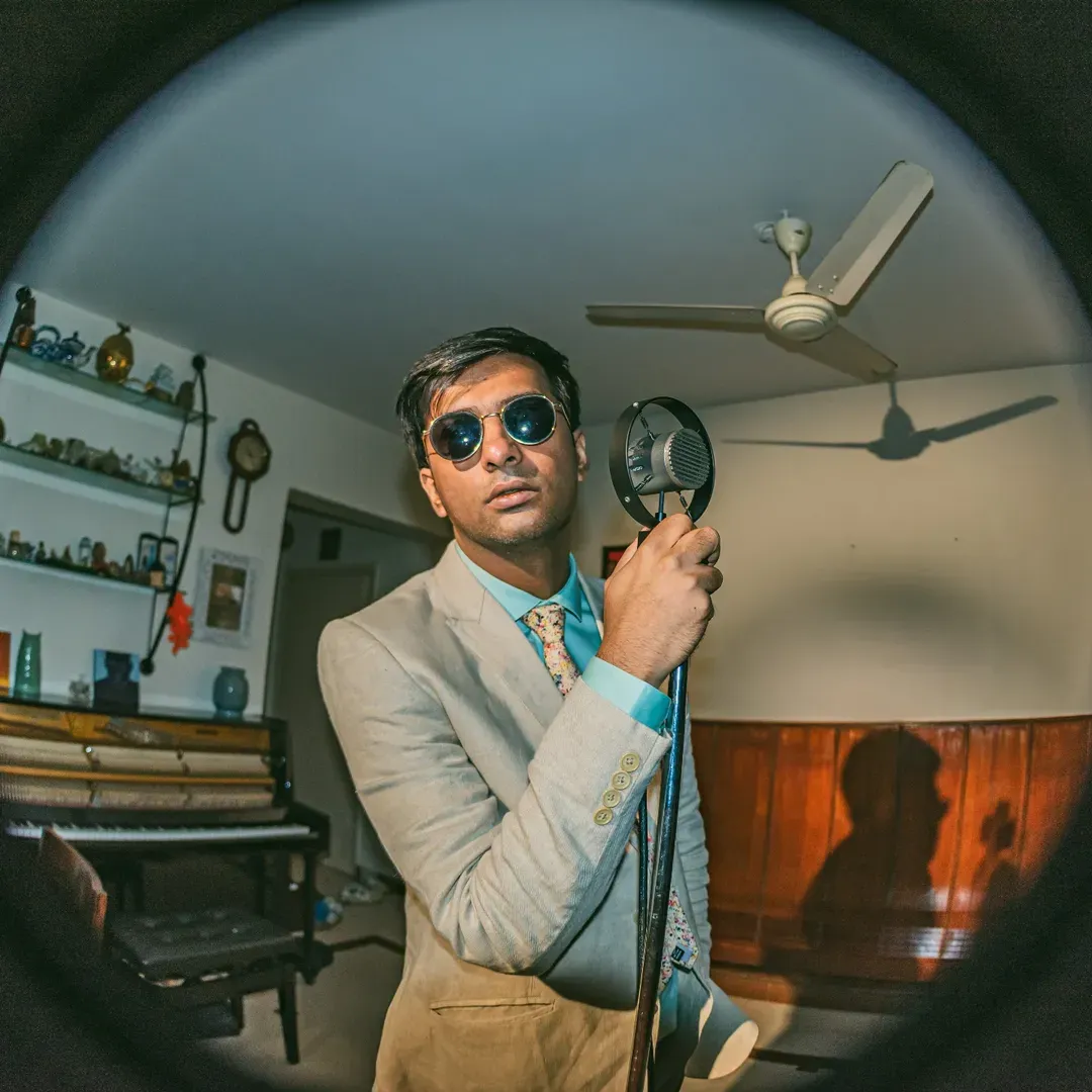 A man poses with a mic to show how the business of musicians in India also involves the cost of releasing music in India, and the rising importance of music marketing in India