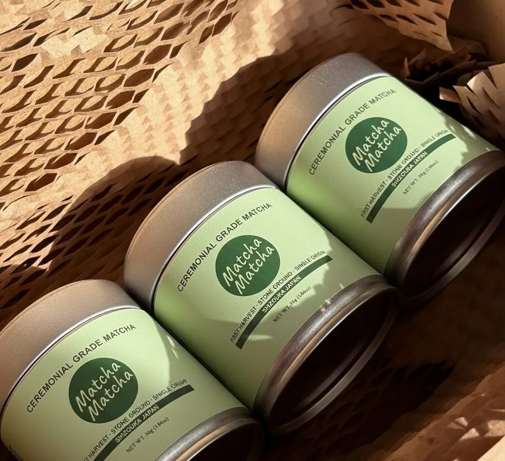 Three tins of Matcha Matcha matcha powder placed in a brown box