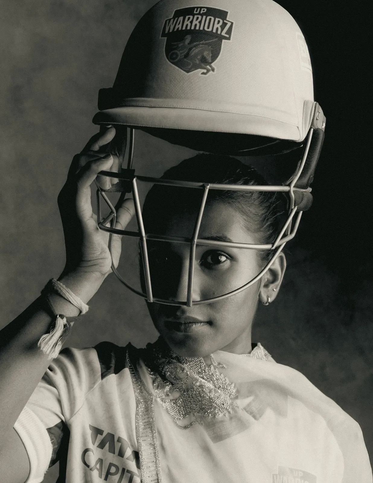Black and white portrait of UP Warriorz player wearing cricket helmet and jersey, emphasising visibility in women&rsquo;s cricket