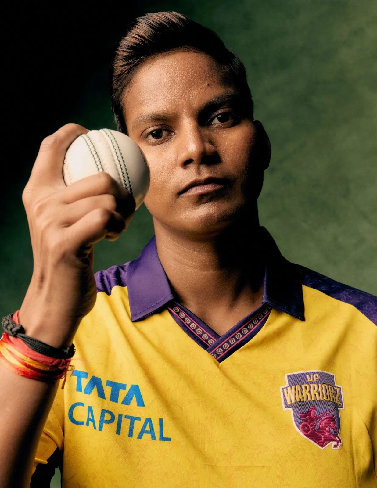 Close-up of UP Warriorz player, Deepti Sharma, holding cricket ball while wearing team jersey by Ekaya Banaras
