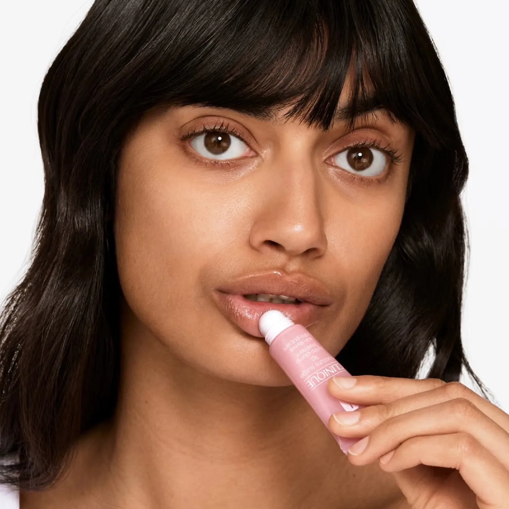A woman applying the best lip balm in India from Clinique