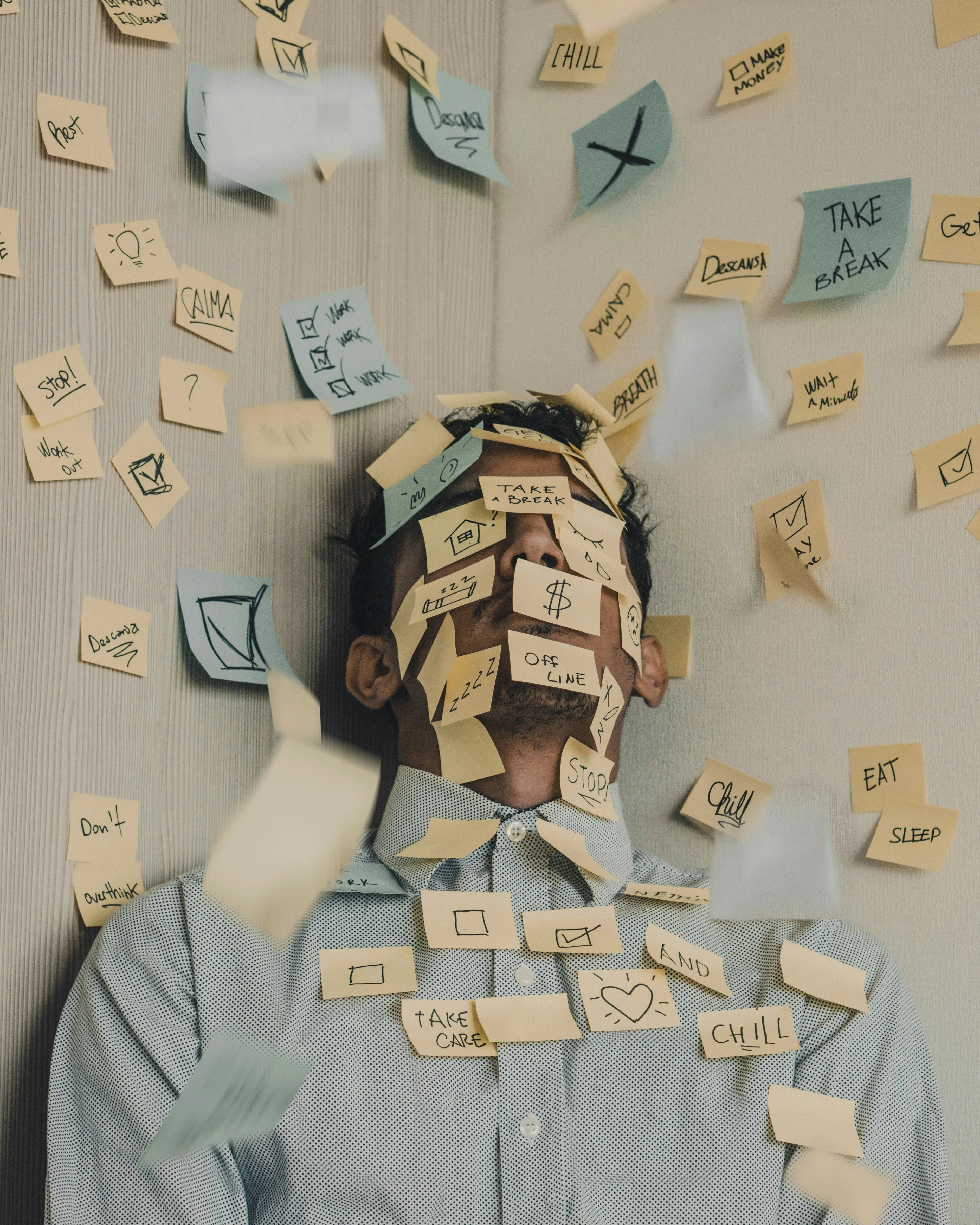 A man covered in post-its to show Gen Z burnout, burnout culture and the impact overstimulation and burnout has on Gen Z mental health.