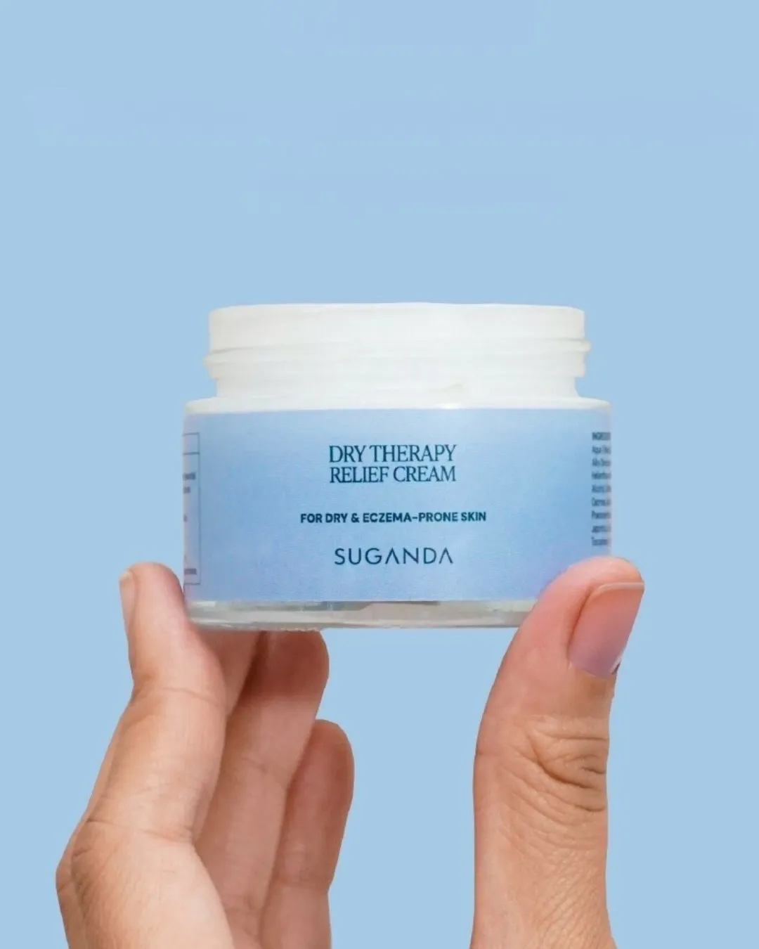 A blue jar of Suganda Dry Relief Therapy Oat Cream that helps calm redness, inflammation and irritation