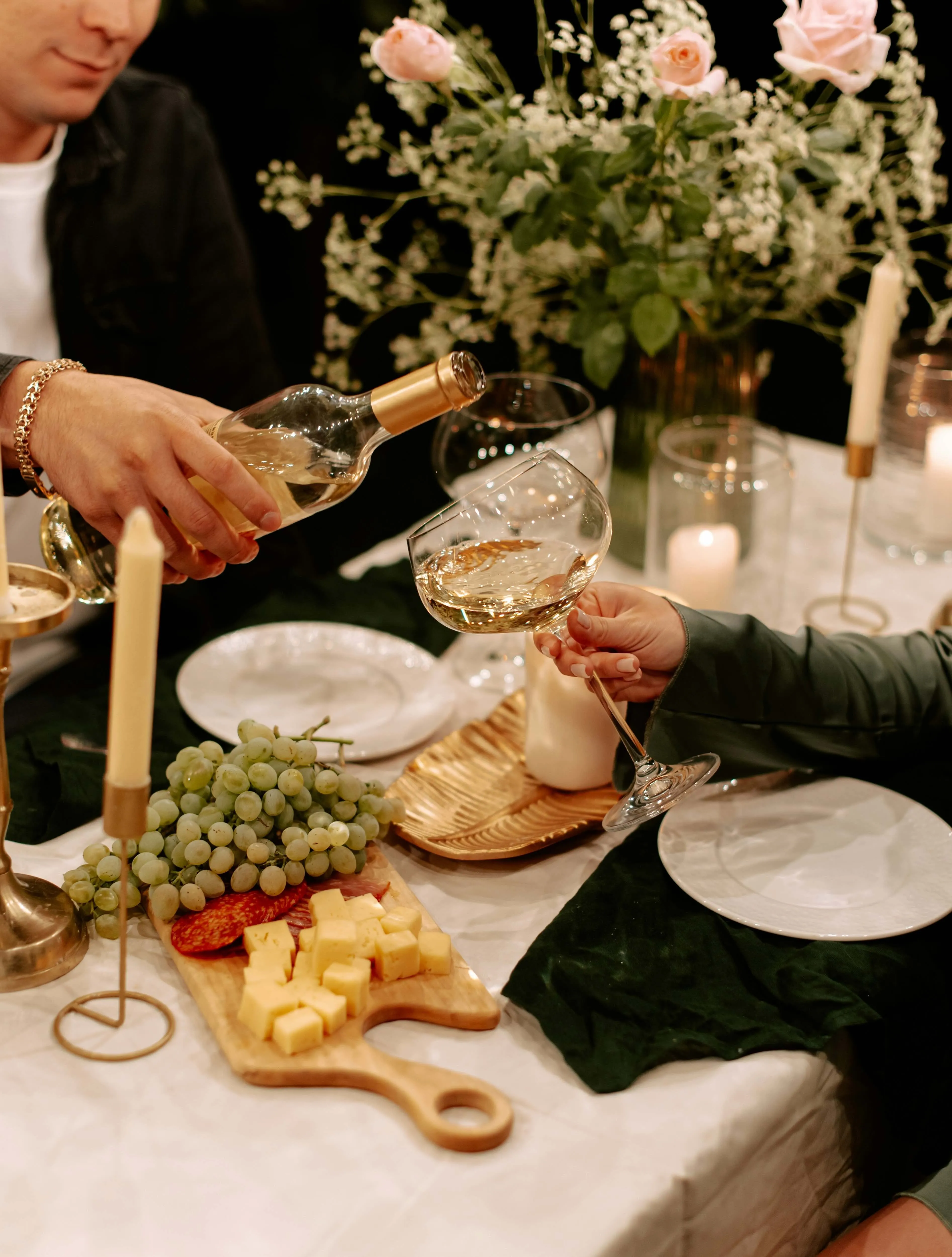 A snippet from a couple's meal at a fancy restaurant, with wine pouring in the glass